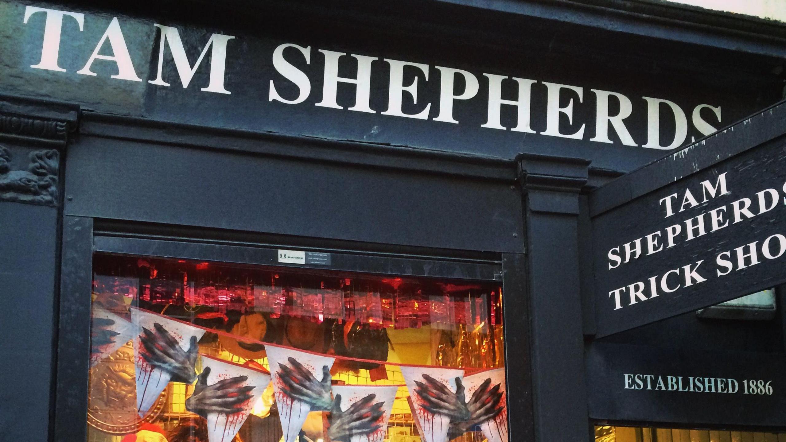 Exterior of Tam Shepherds - Shop front painted black with white text reading "Tam Shepherds".