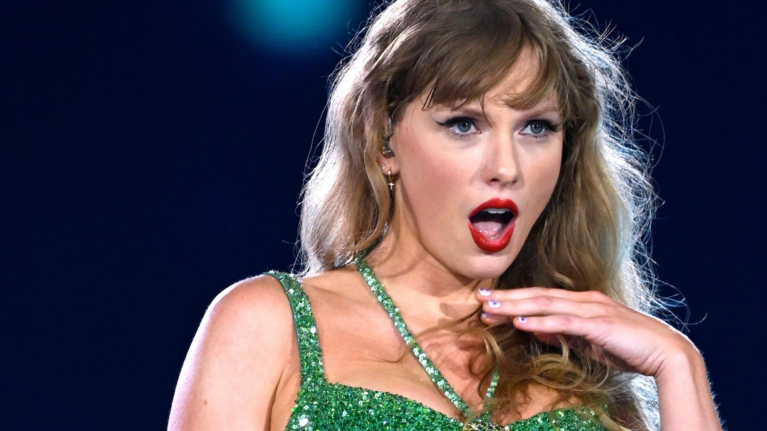 Taylor Swift plays at Wembley Stadium, in a green strapy dress