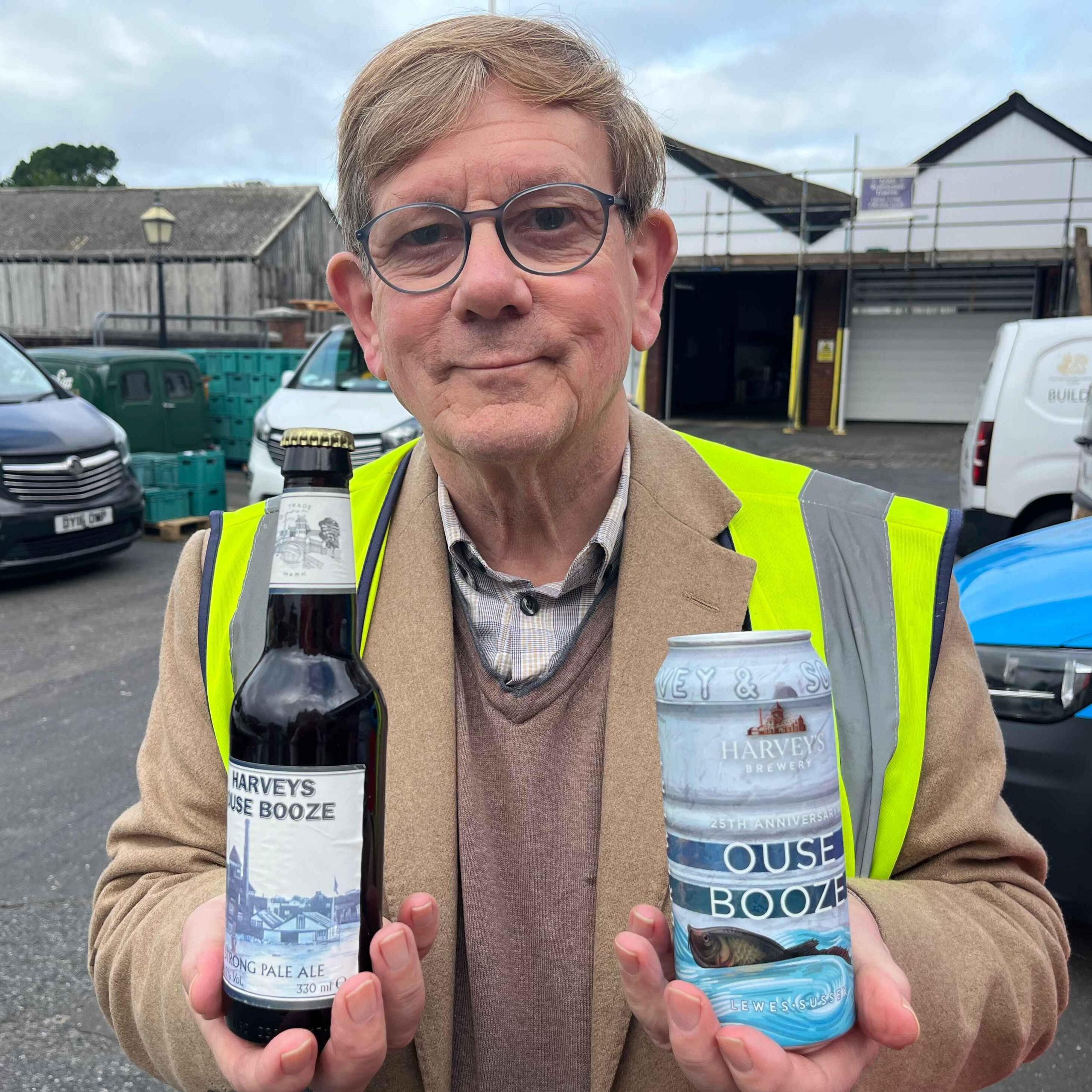 Miles Jenner holding a bottle of original harvey's ouse booze and their 25th anniversary edition which is in a can