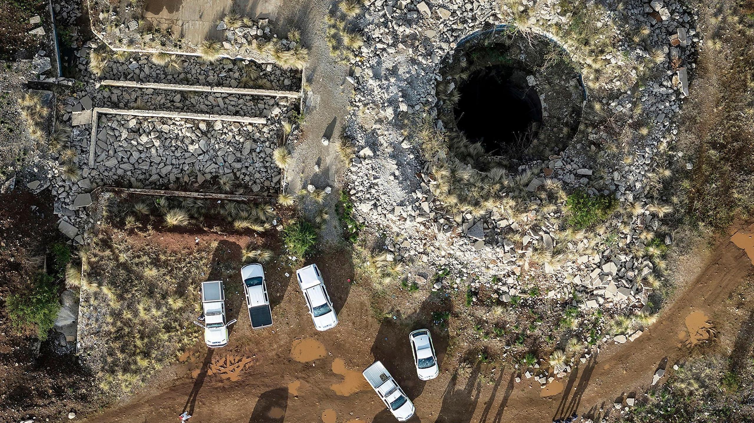 Aerial view of one of the mine shafts of the Stilfontein mine in South Africa, with police vehicles parked nearby.