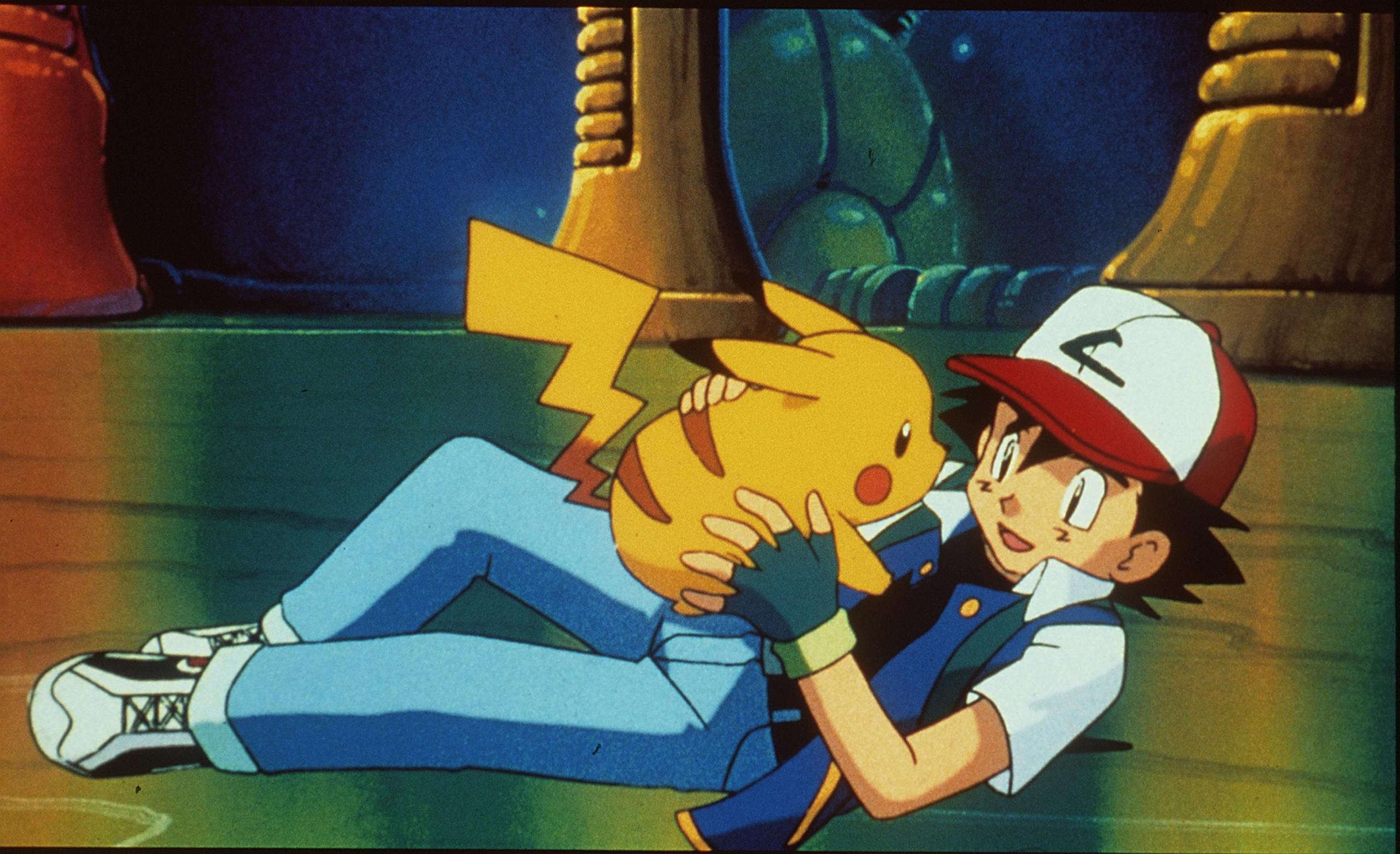 a still from the Pokémon movie where ash Ketchum is hugging Pikachu and smiling.