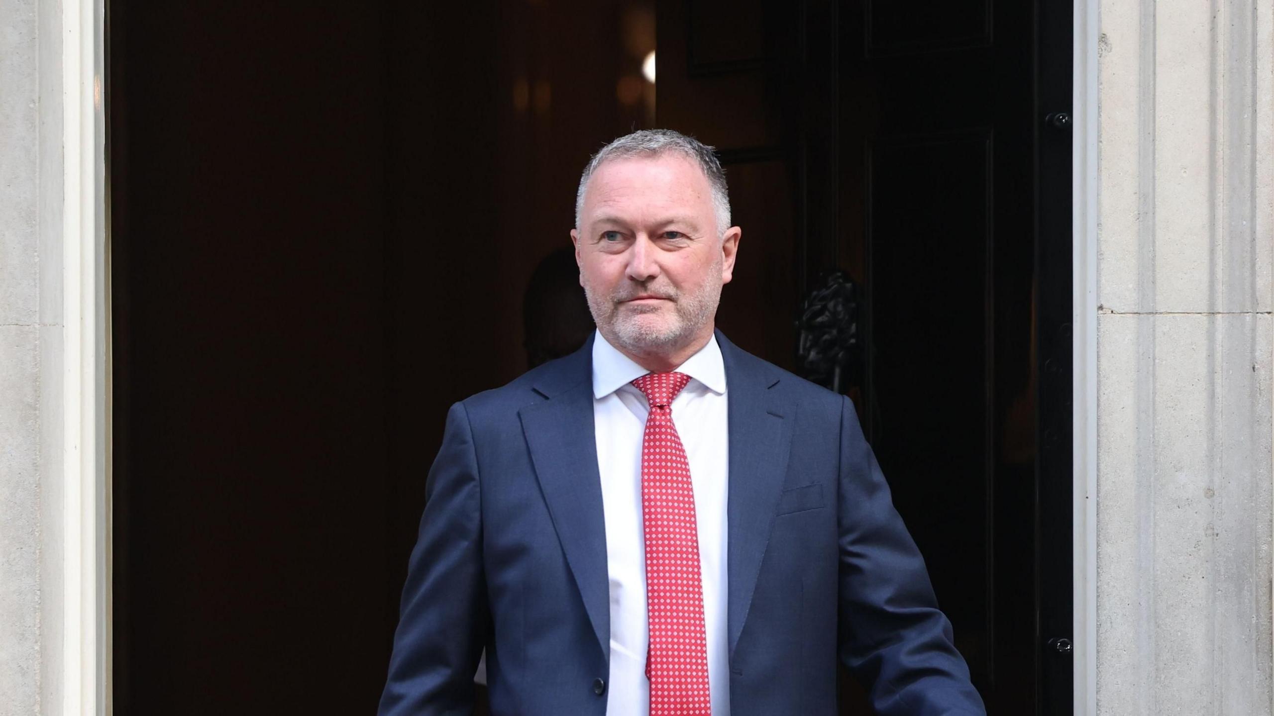 Housing secretary Steve Reed coming out of 10 Downing Street in a blue suit with red tie