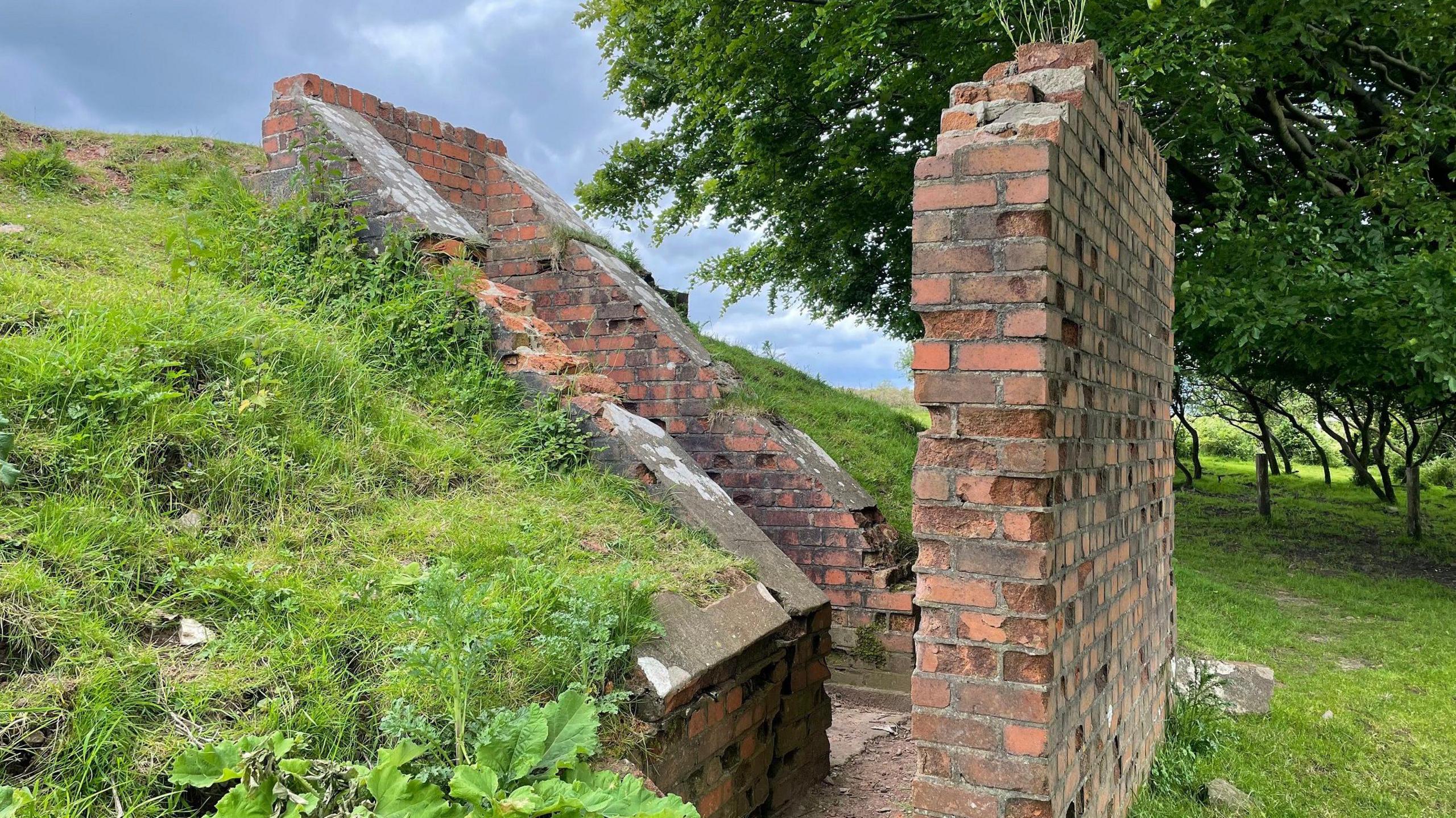 The outside of a disused bunker with a blast wall