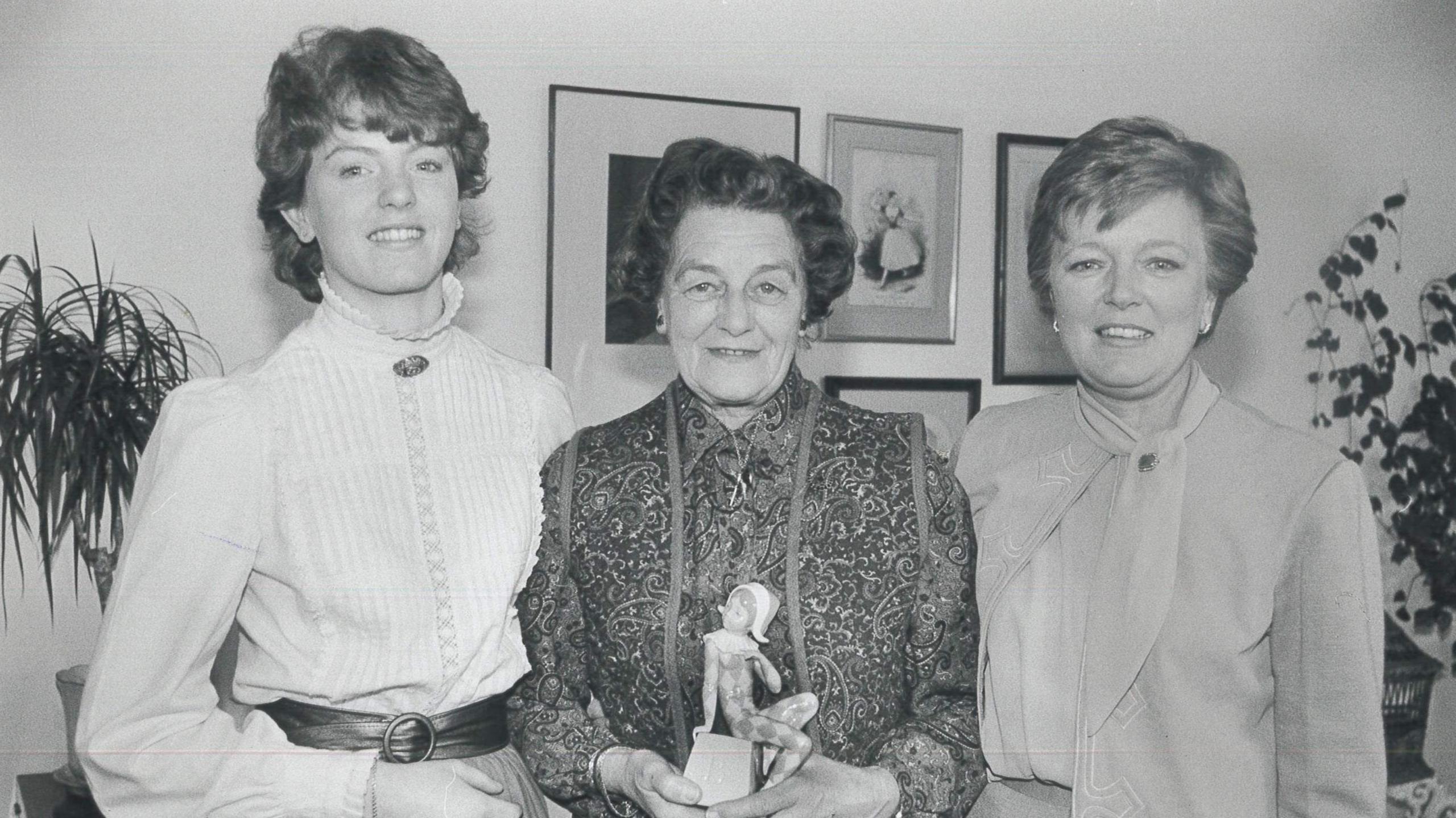 A black and white image of Ms Smith standing in between her daughter and granddaughter.