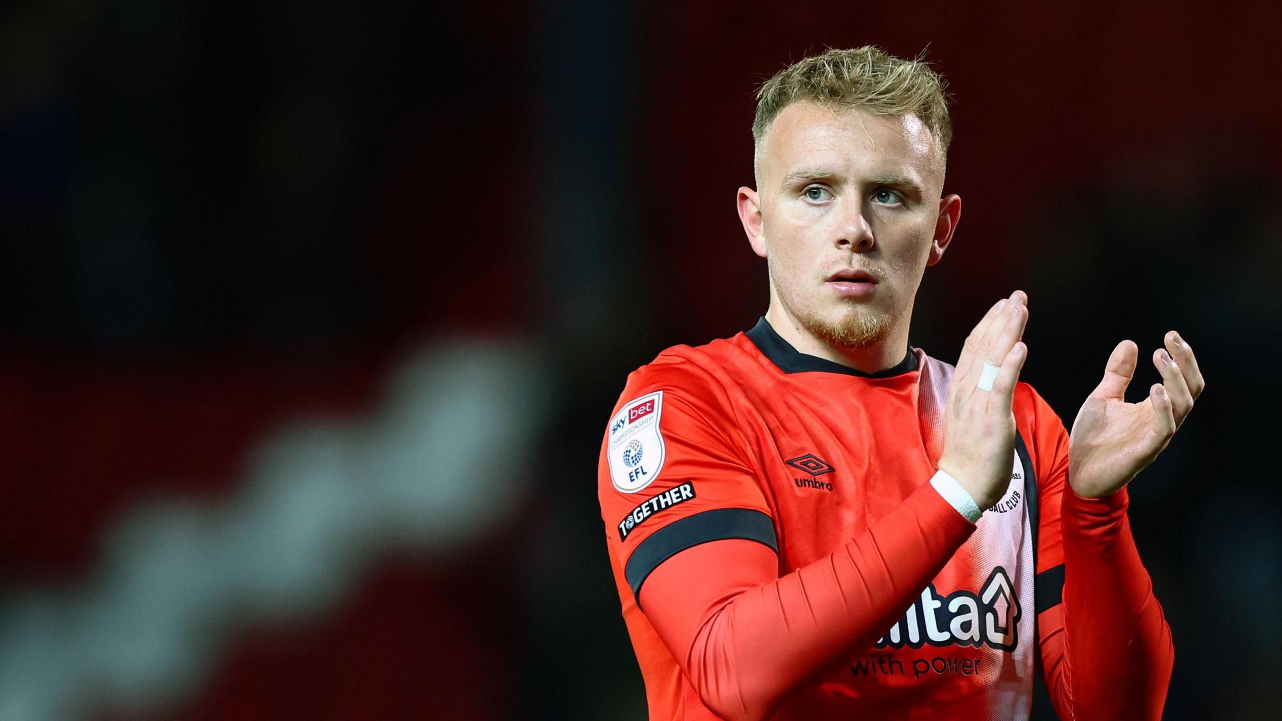 Joe Taylor claps as he leaves the pitch for Luton