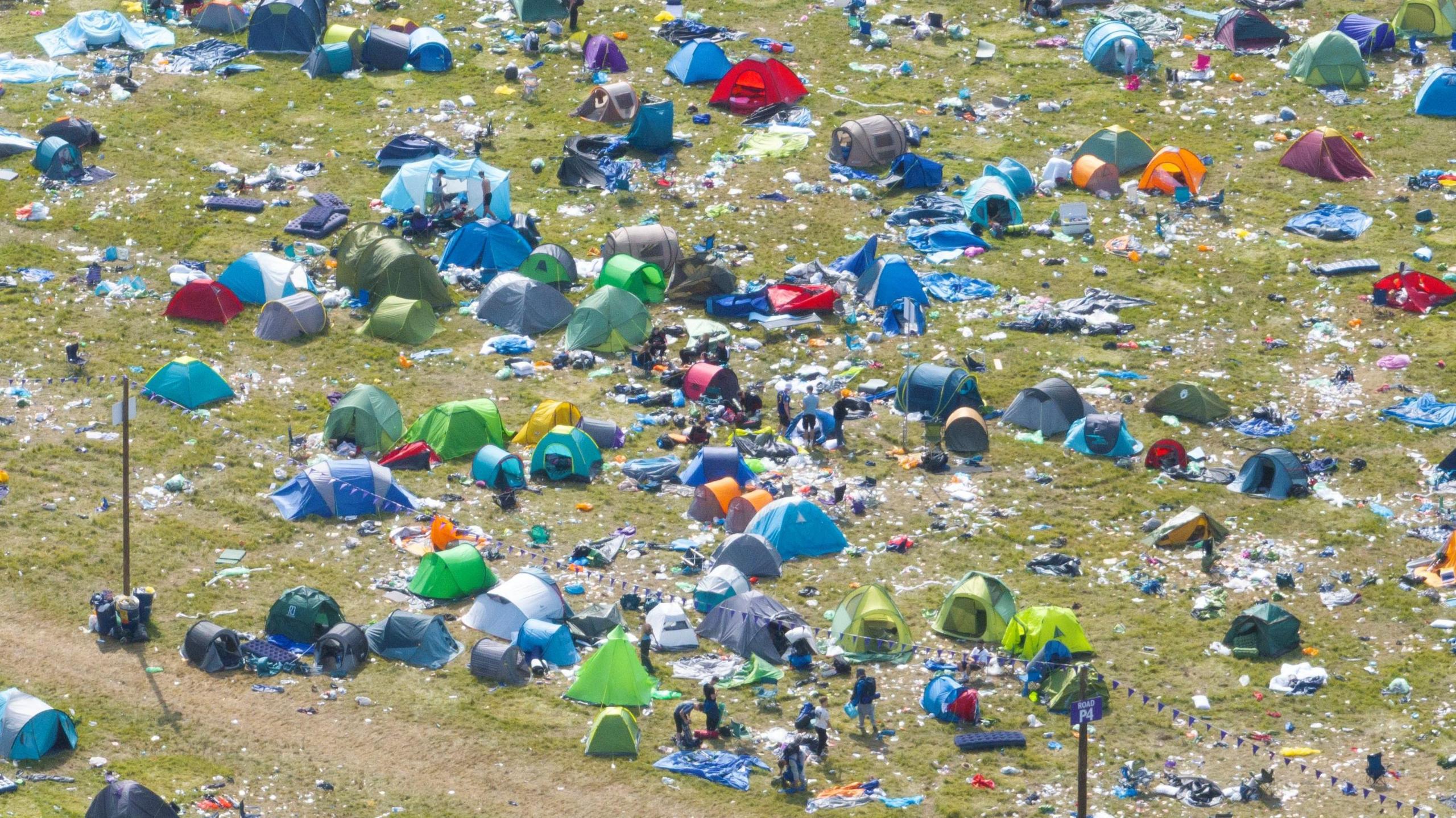 Close up, taken by a drone, of Reading Festival aftermath of green and blue tents and plastic and paper rubbish left behind by festival-goers.