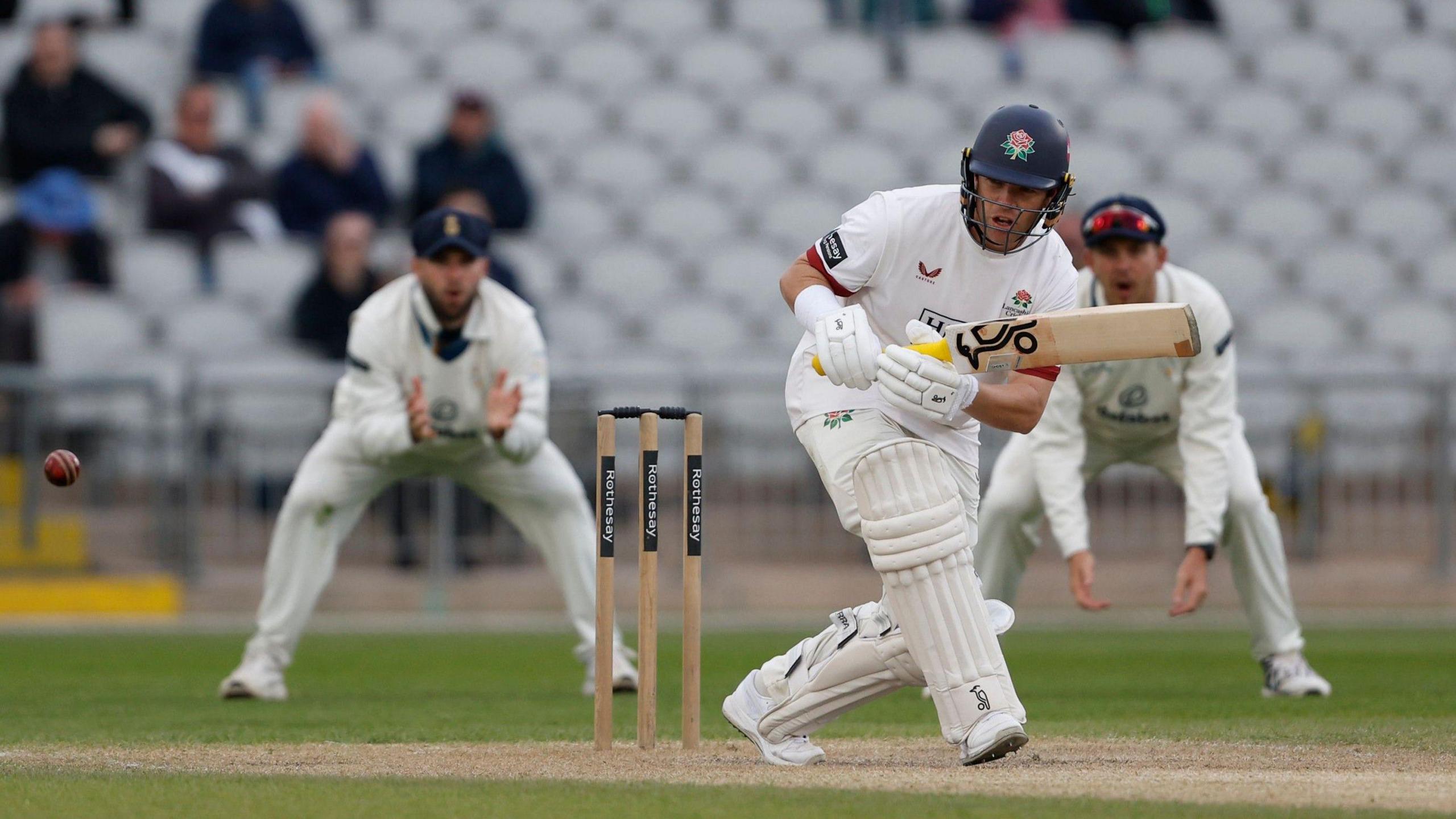 Marcus Harris clips the ball square on the on side and begins to run, wearing blue helmet with red rose emblem. Two opposition fielders are seen fielding in the slips behind him