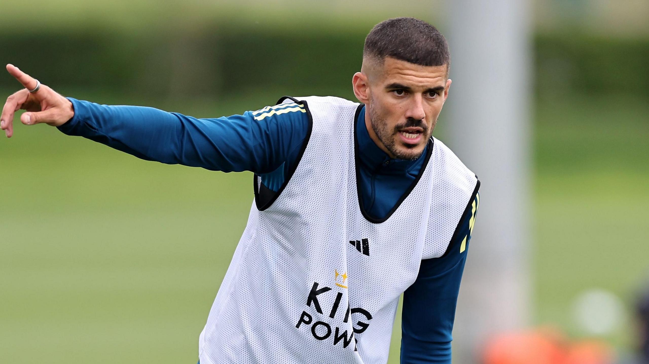 Conor Coady points with his right hand during a Leicester City training session