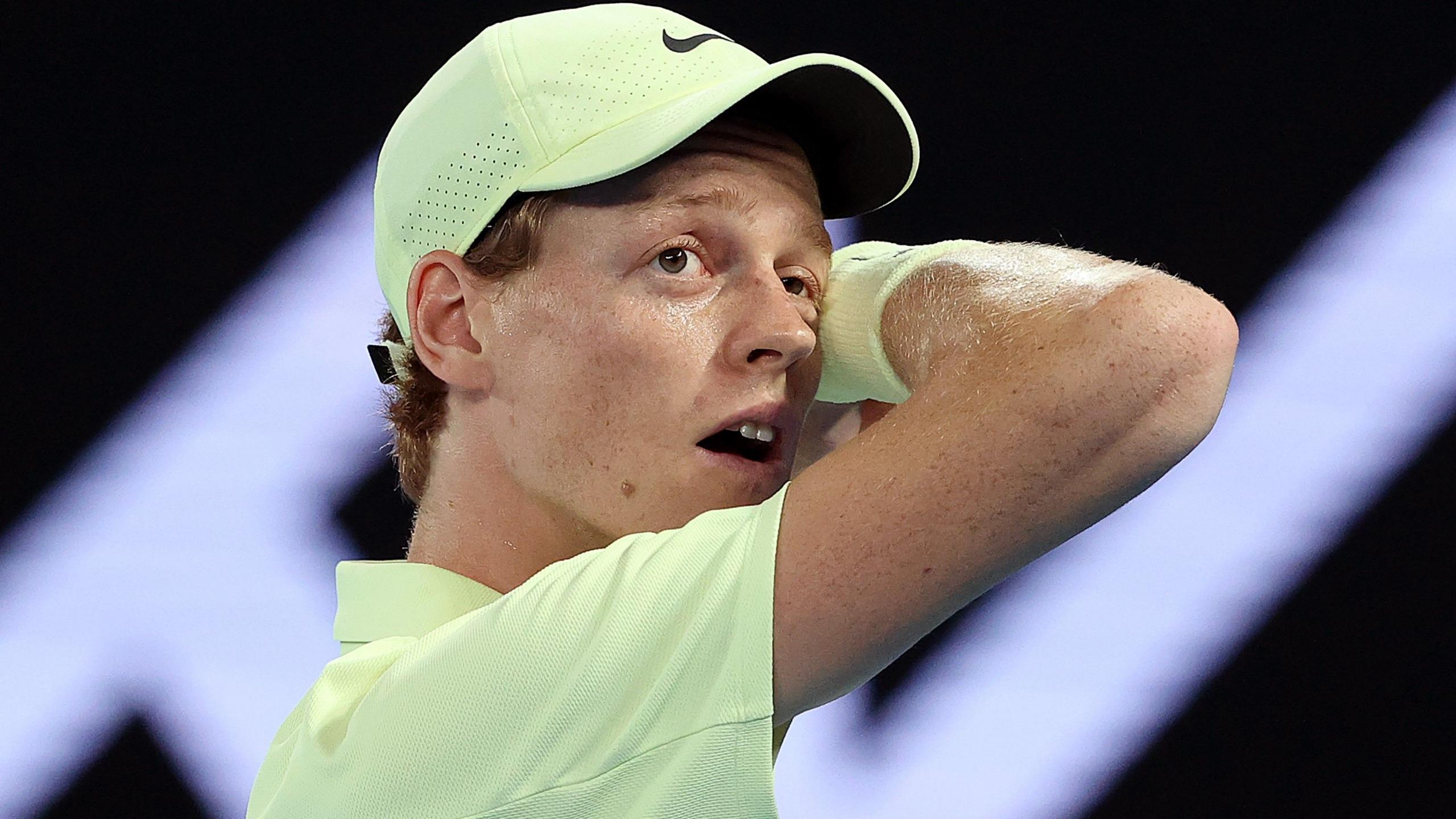 Jannik Sinner wipes his face with a sweatband during a charity match at the Australian Open