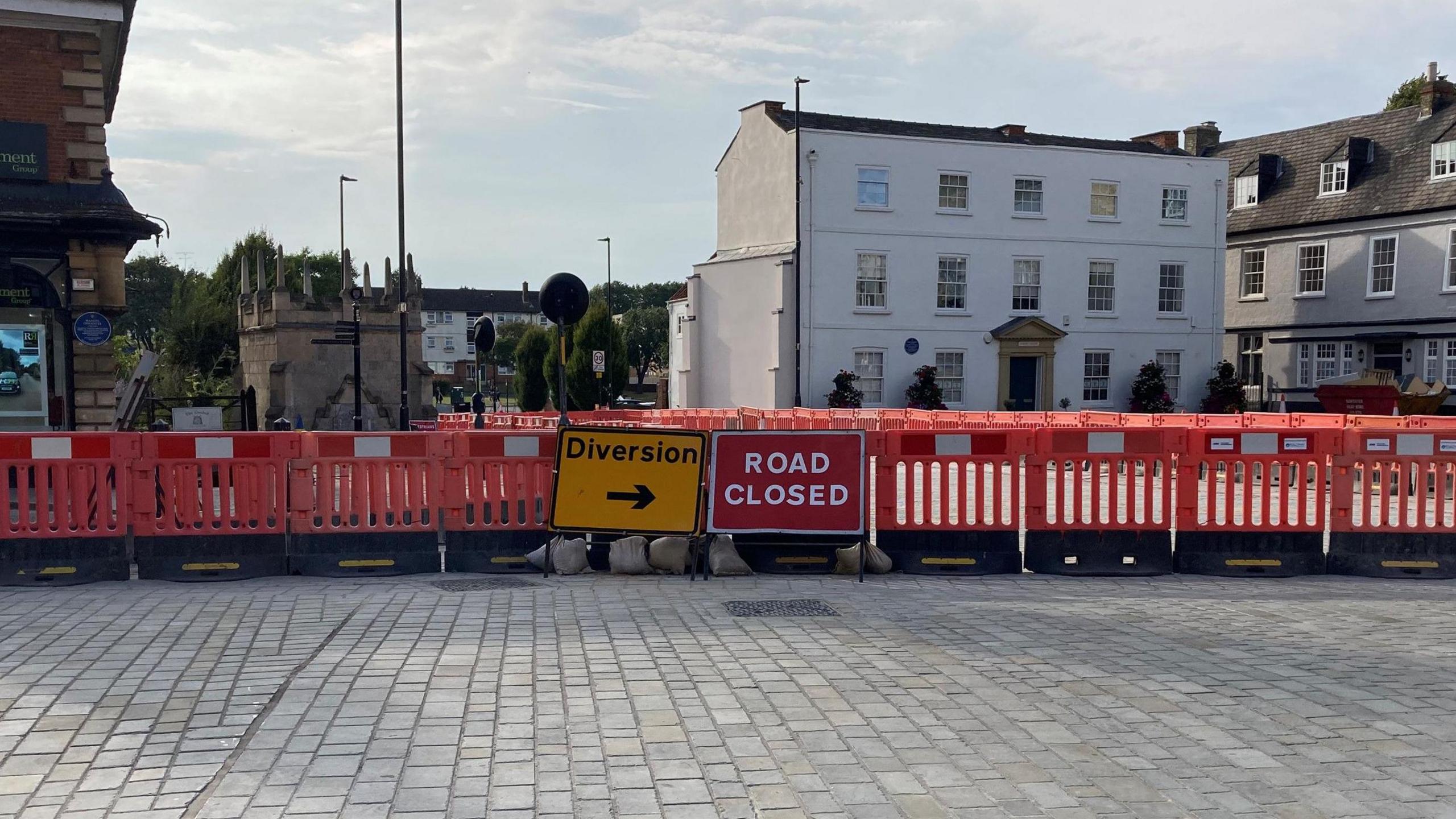 Red barrier fencing in the Market Place area with road closed and diversion signs in place