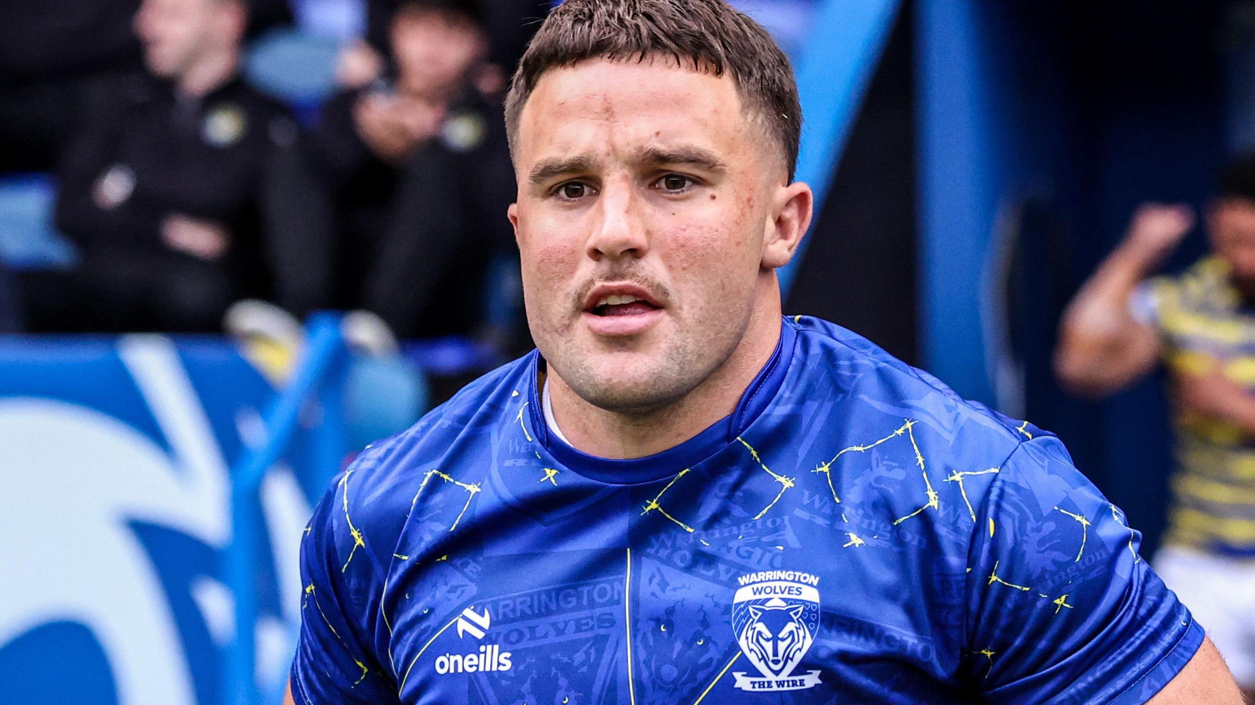 Josh Smith in blue Warrington shirt runs onto the pitch