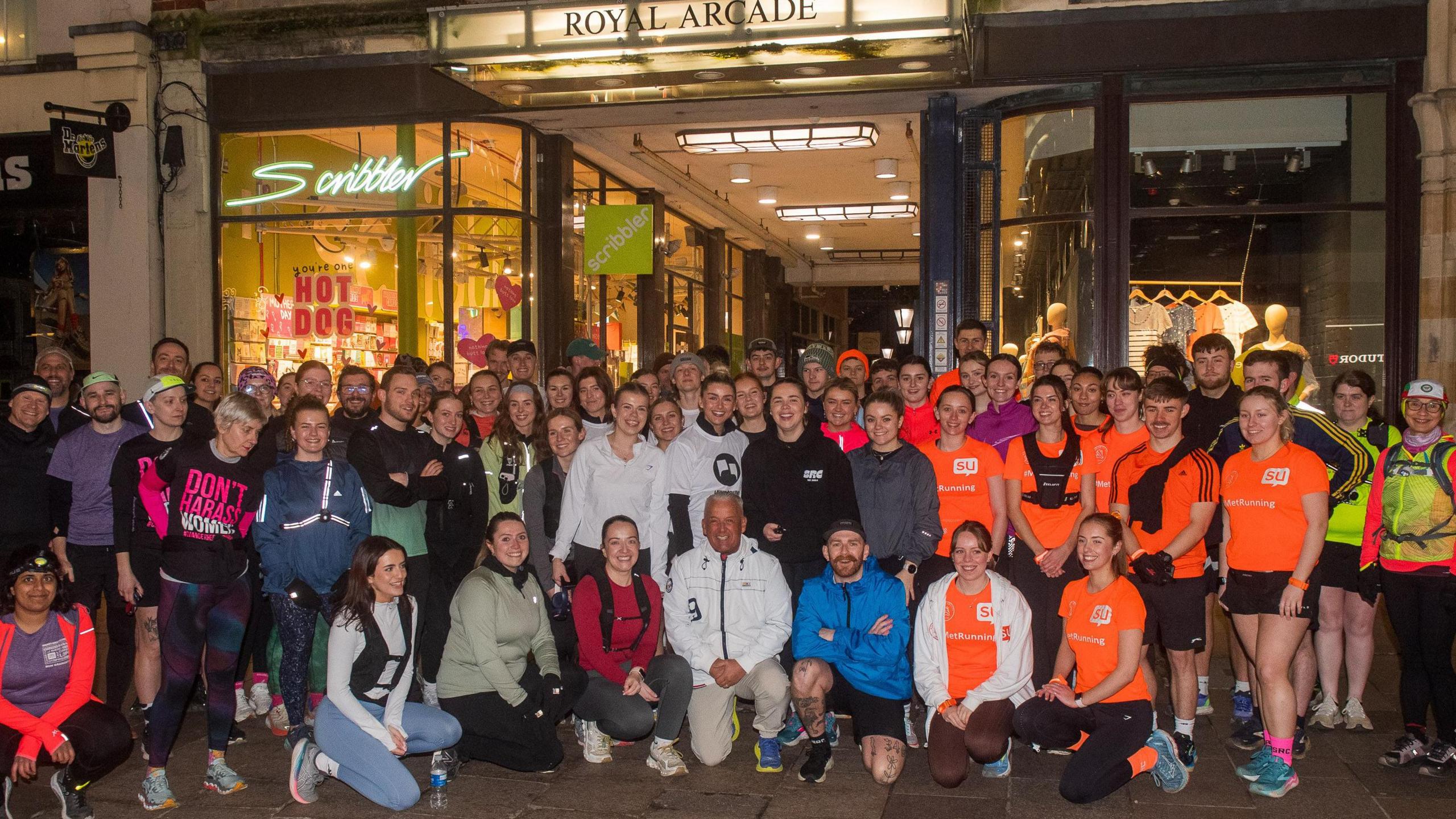 About 71 runners in luminous sportswear pose for a photo outside the Royal Arcade in Cardiff. 