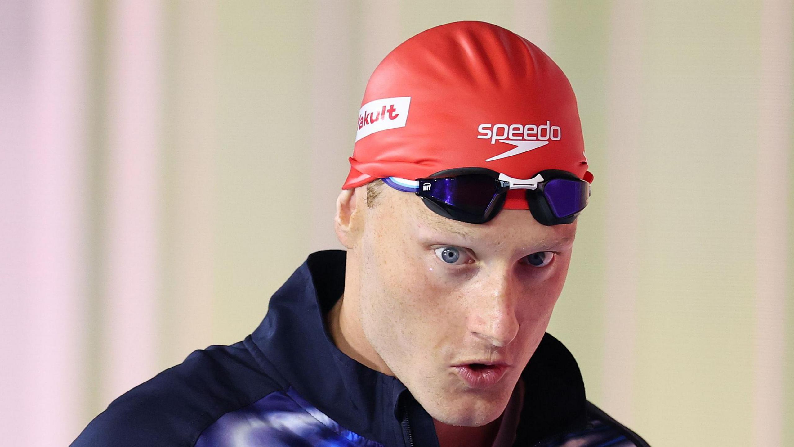 Luke Greenbank wearing a red swimming cap at the 2025 World Aquatics Championships
