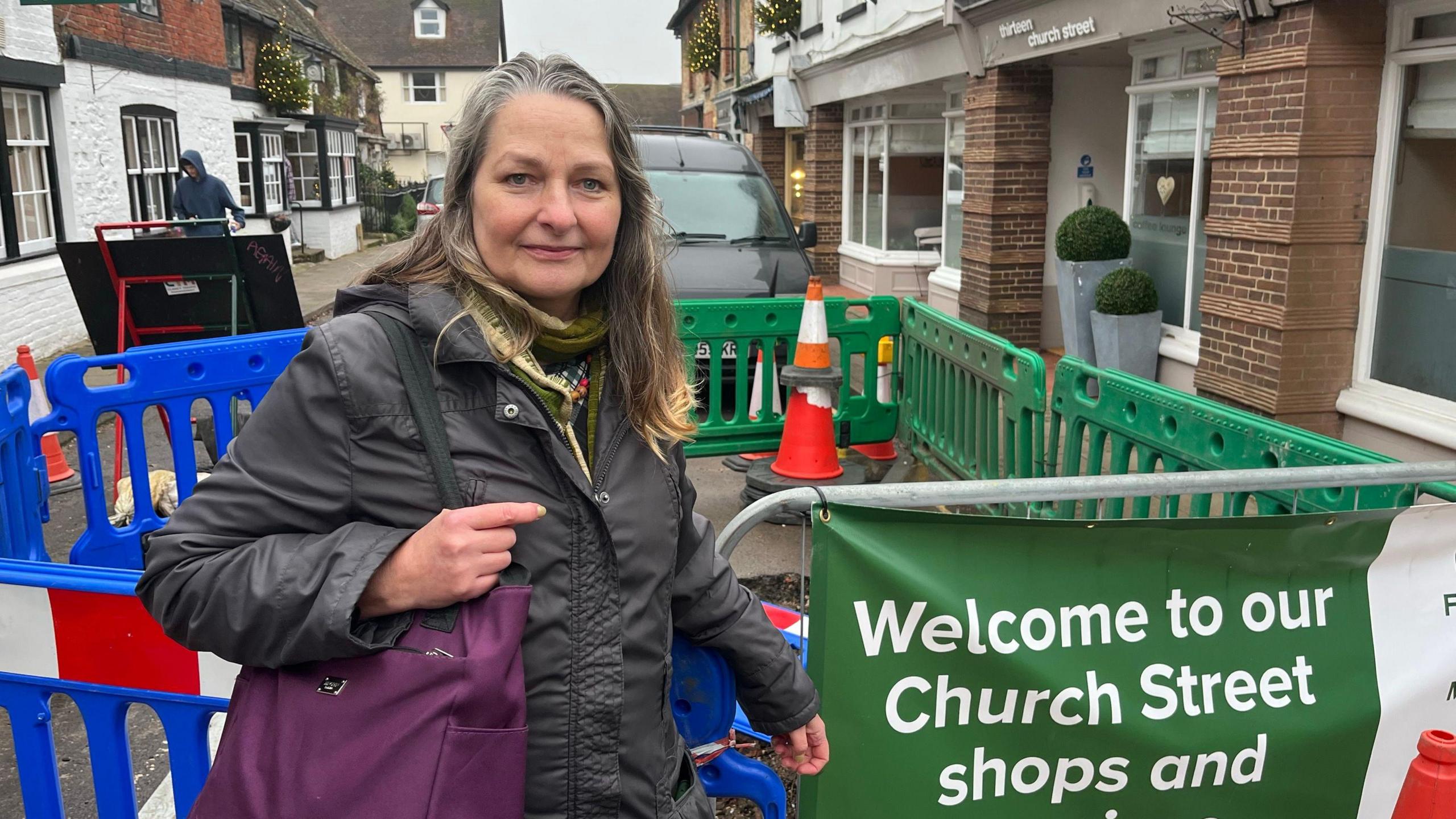 Claudia Fisher stood in front of the sinkhole with a sign next to her saying welcome to Church Street. The sinkhole is cordoned by plastic fencing