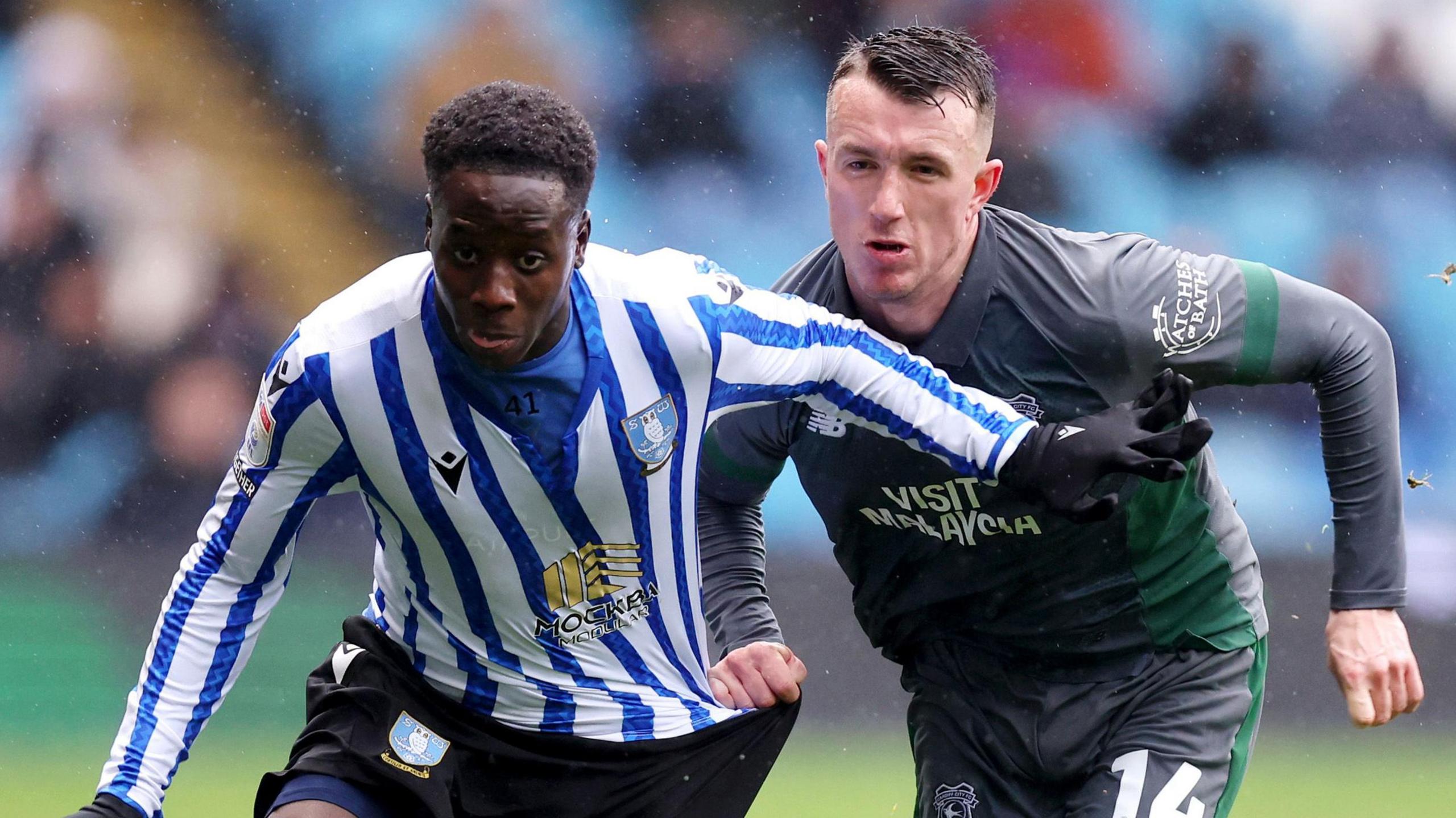 Djeidi Gassama of Sheffield Wednesday (left) breaks away from David Turnbull of Cardiff City 