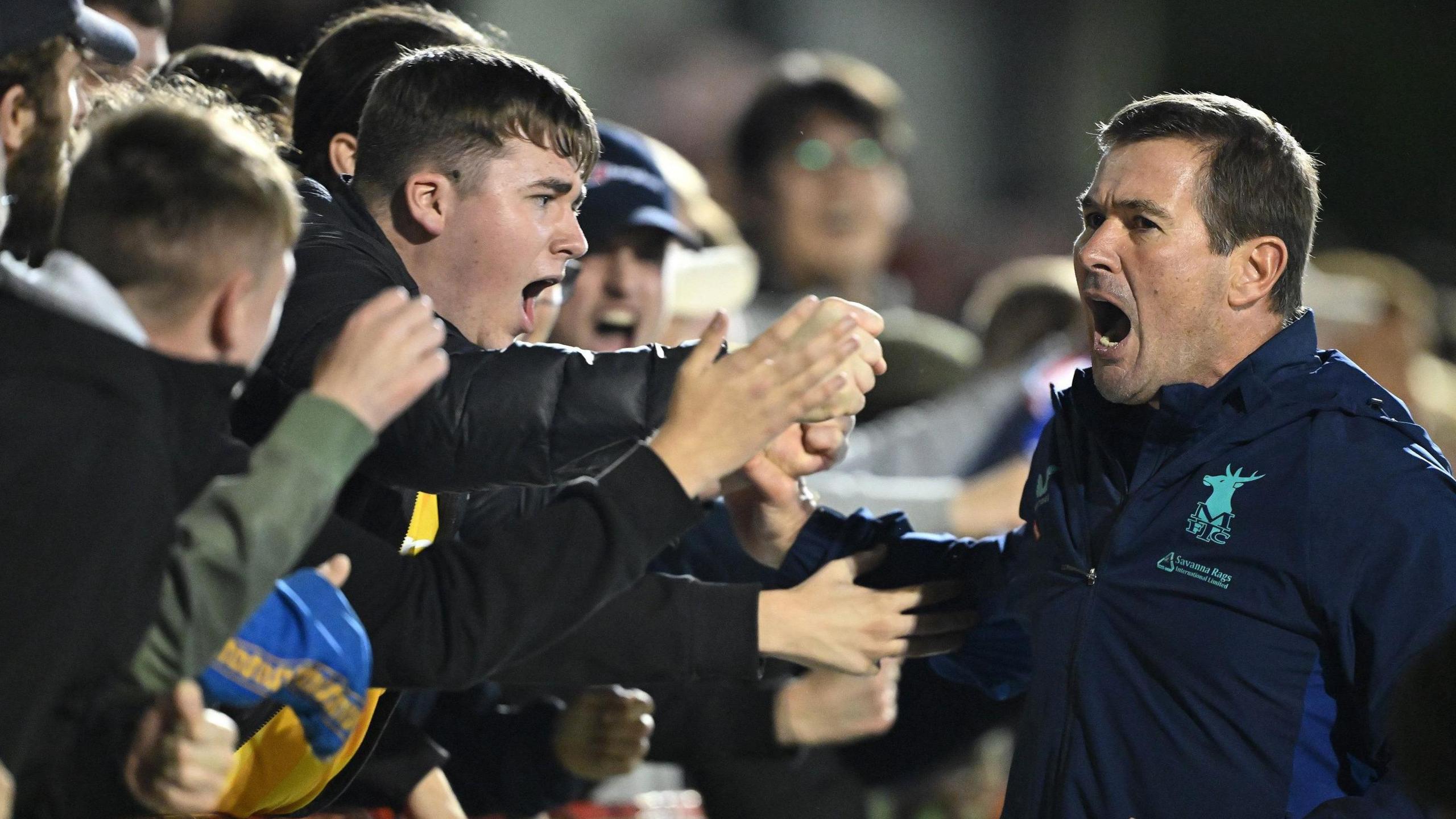 Mansfield boss Nigel Clough celebrates a win with the club's supporters