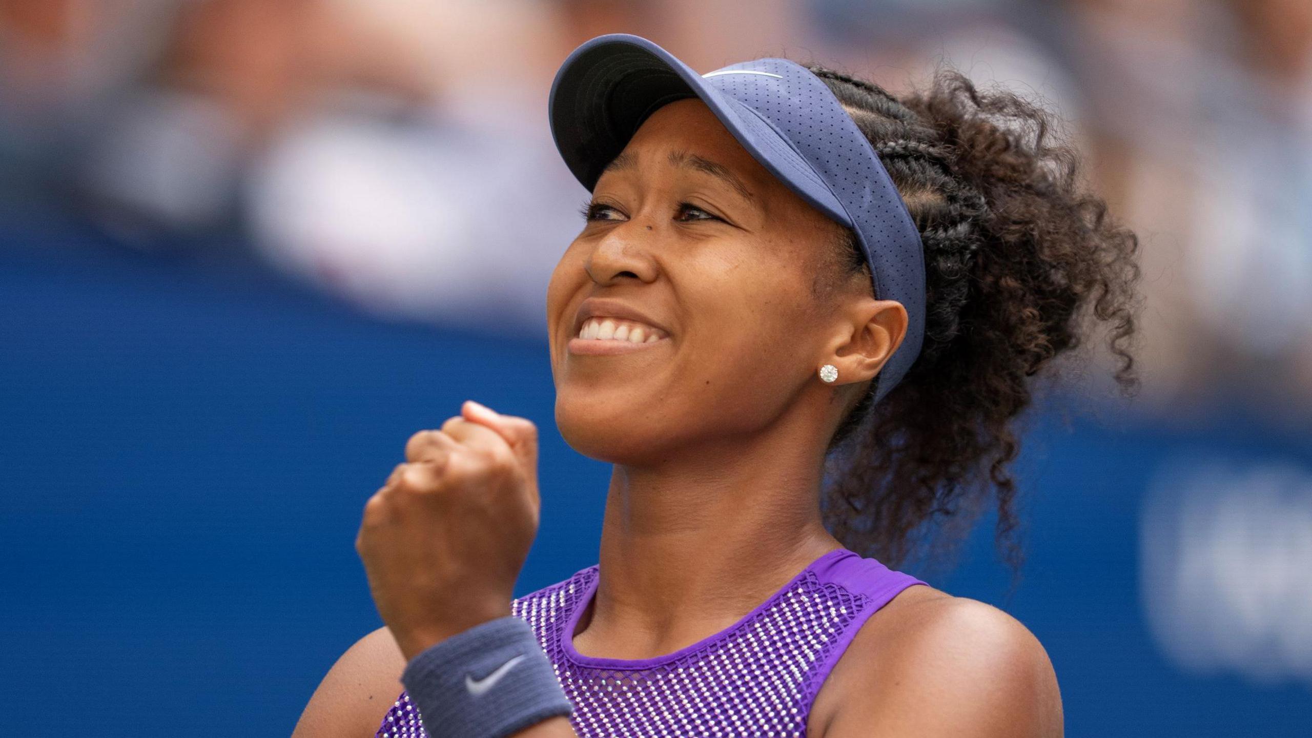 Naomi Osaka smiles after beating Coco Gauff at the 2025 US Open