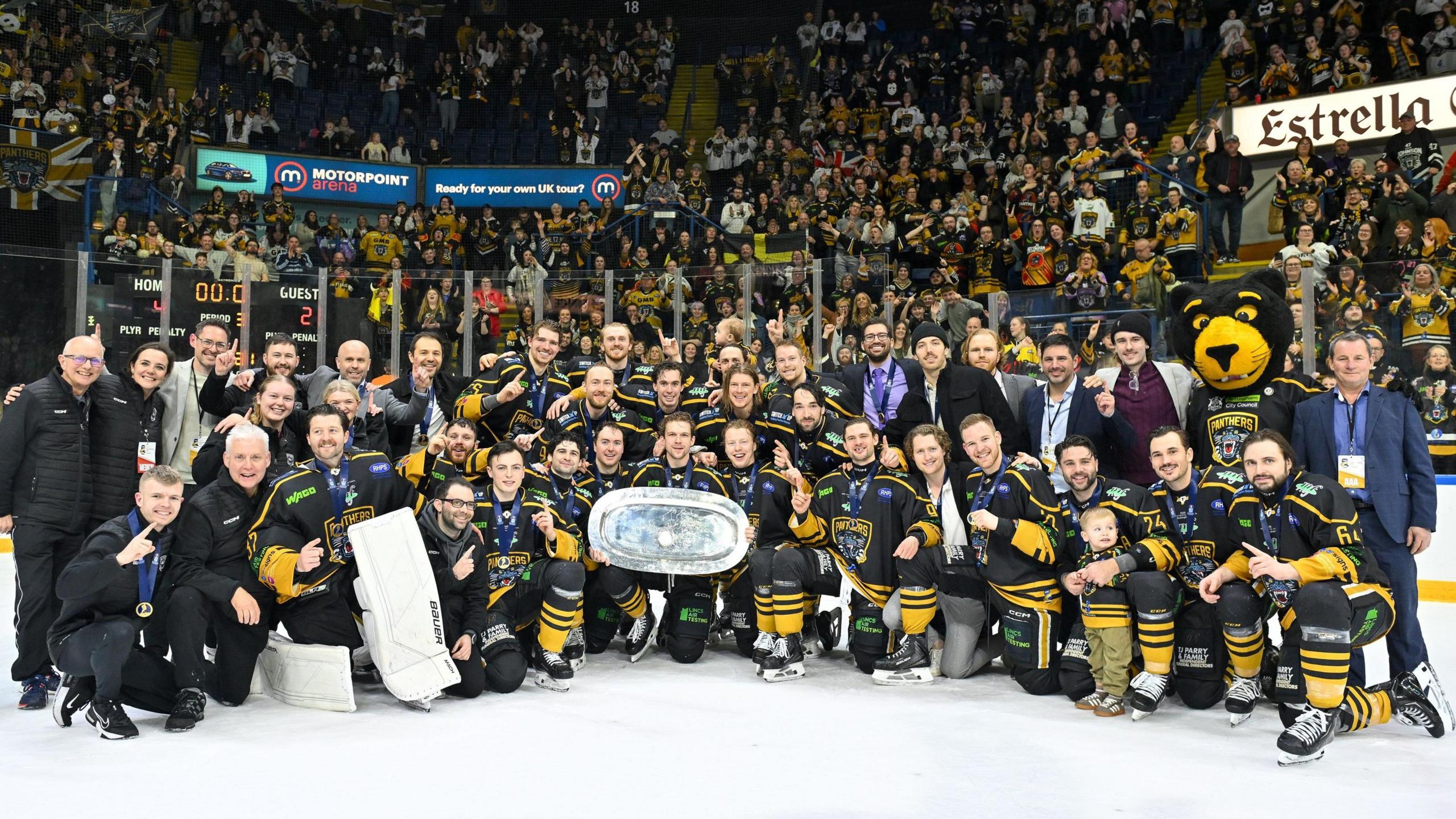 Nottingham Panthers players, coaches and staff celebrate their Continental Cup triumph with a picture in front of supporters in the stands