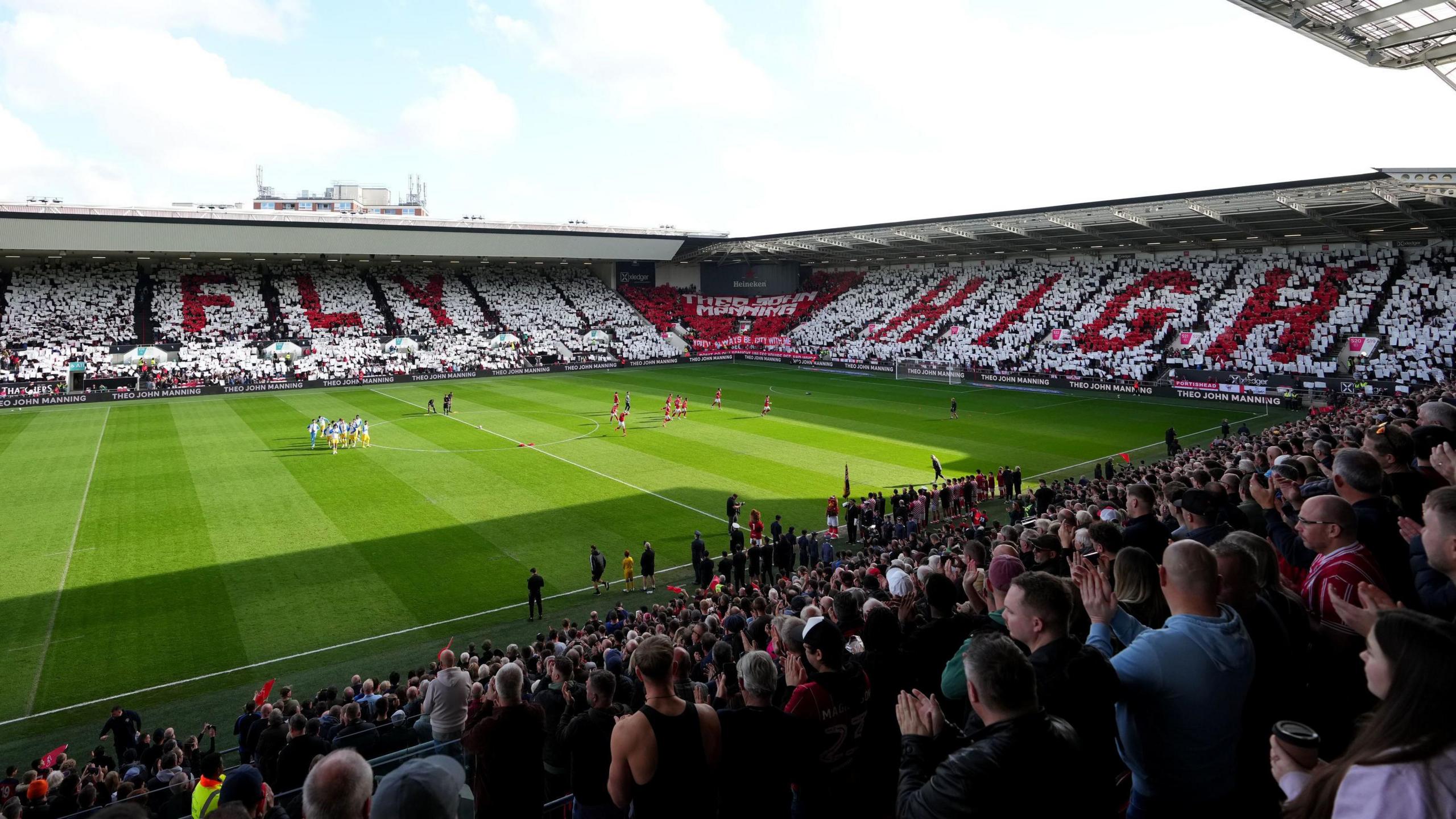 A huge display organised by Bristol City supporters before the match with Leeds United at Ashton Gate. Thousands of fans are holding white and red coloured squares aloft spelling out "FLY" and "HIGH" in different stands in tribute to the son of manager Liam Manning after he died.