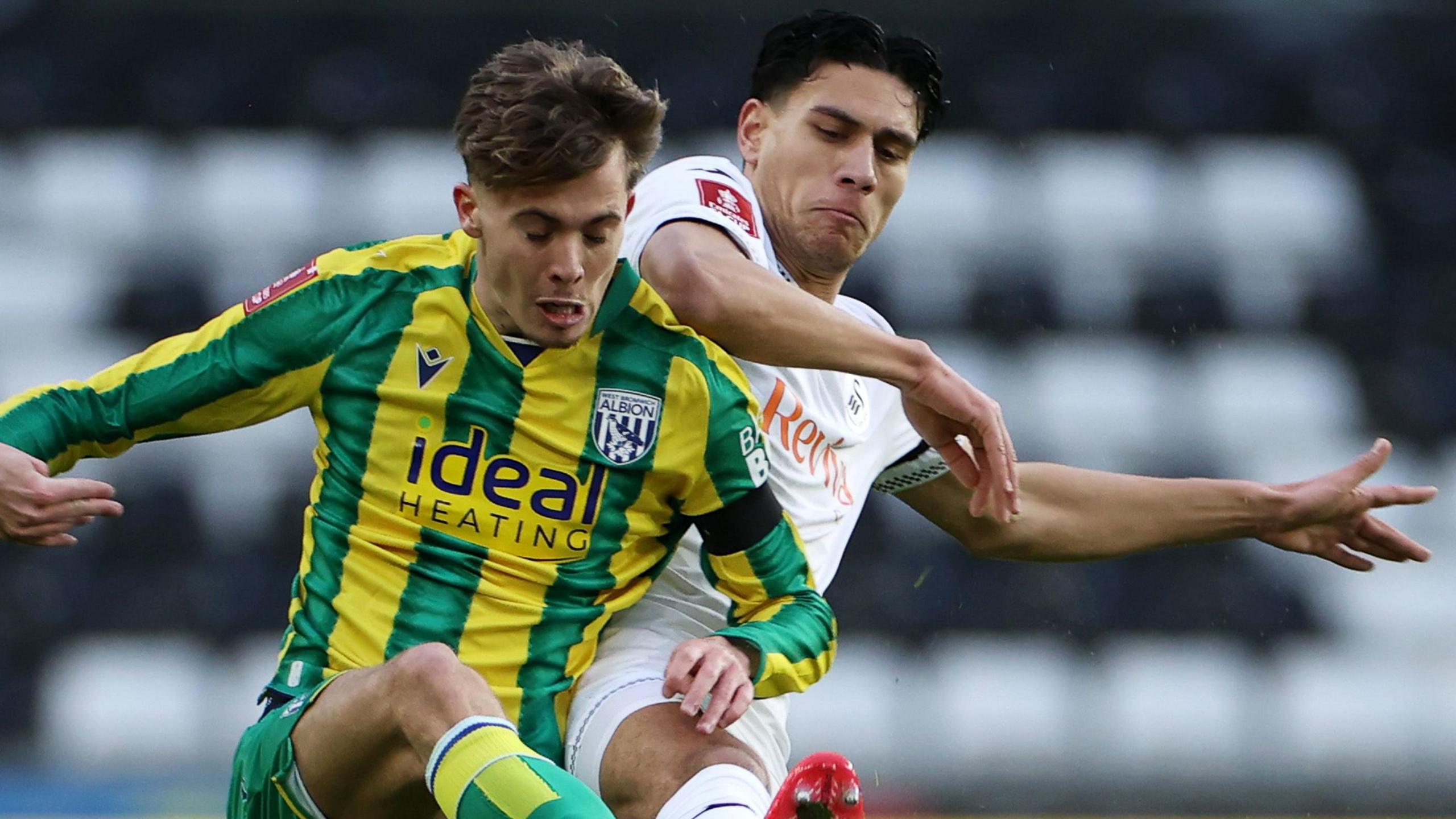 Isaac Price (left) of West Brom is tackled by Marko Stamenic of Swansea City