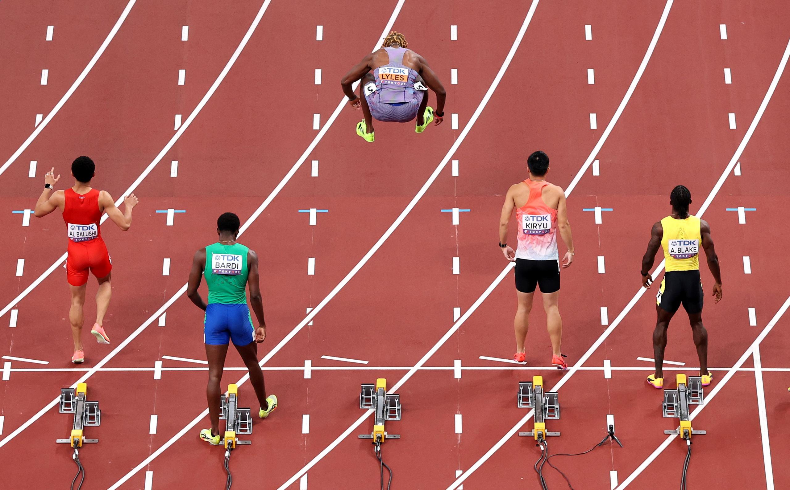 Noah Lyles jumps in the air on the start line for the 100m heats at the World Athletics Championships in Tokyo