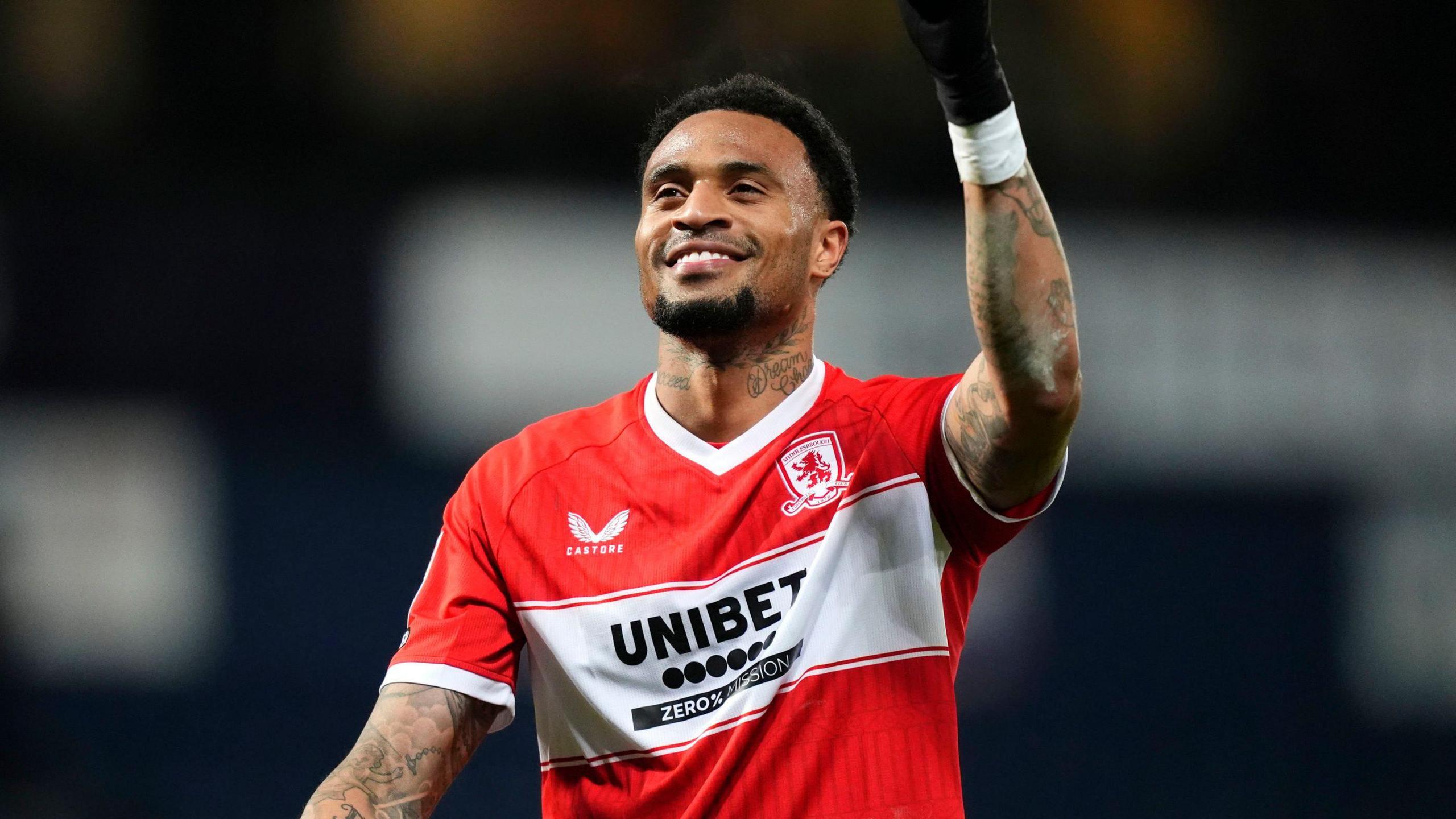 Delano Burgzorg smiles and holds his left arm in the air during a match for Middlesbrough