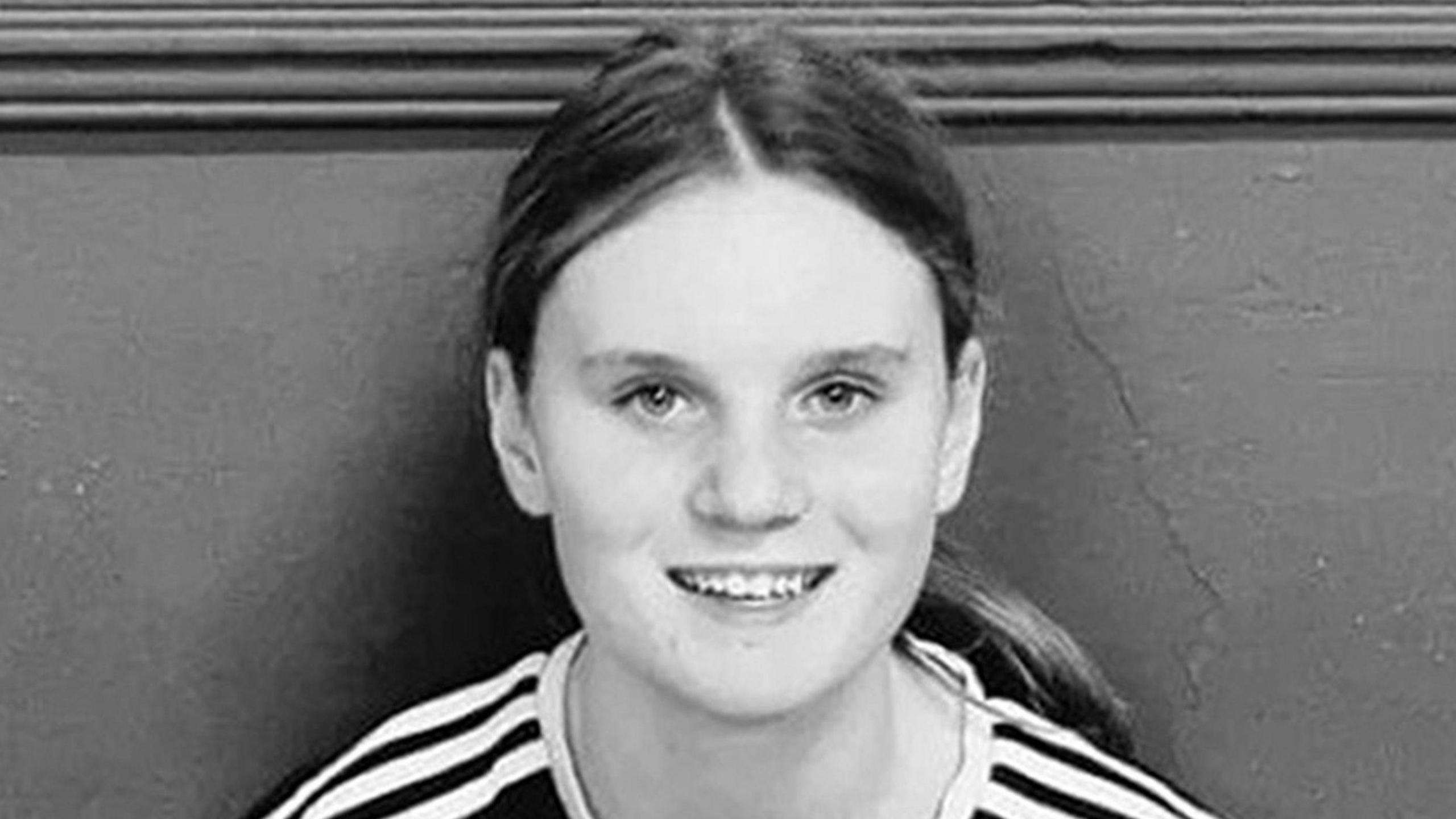 Black and white picture of a teenage girl with long hair in a pony tail