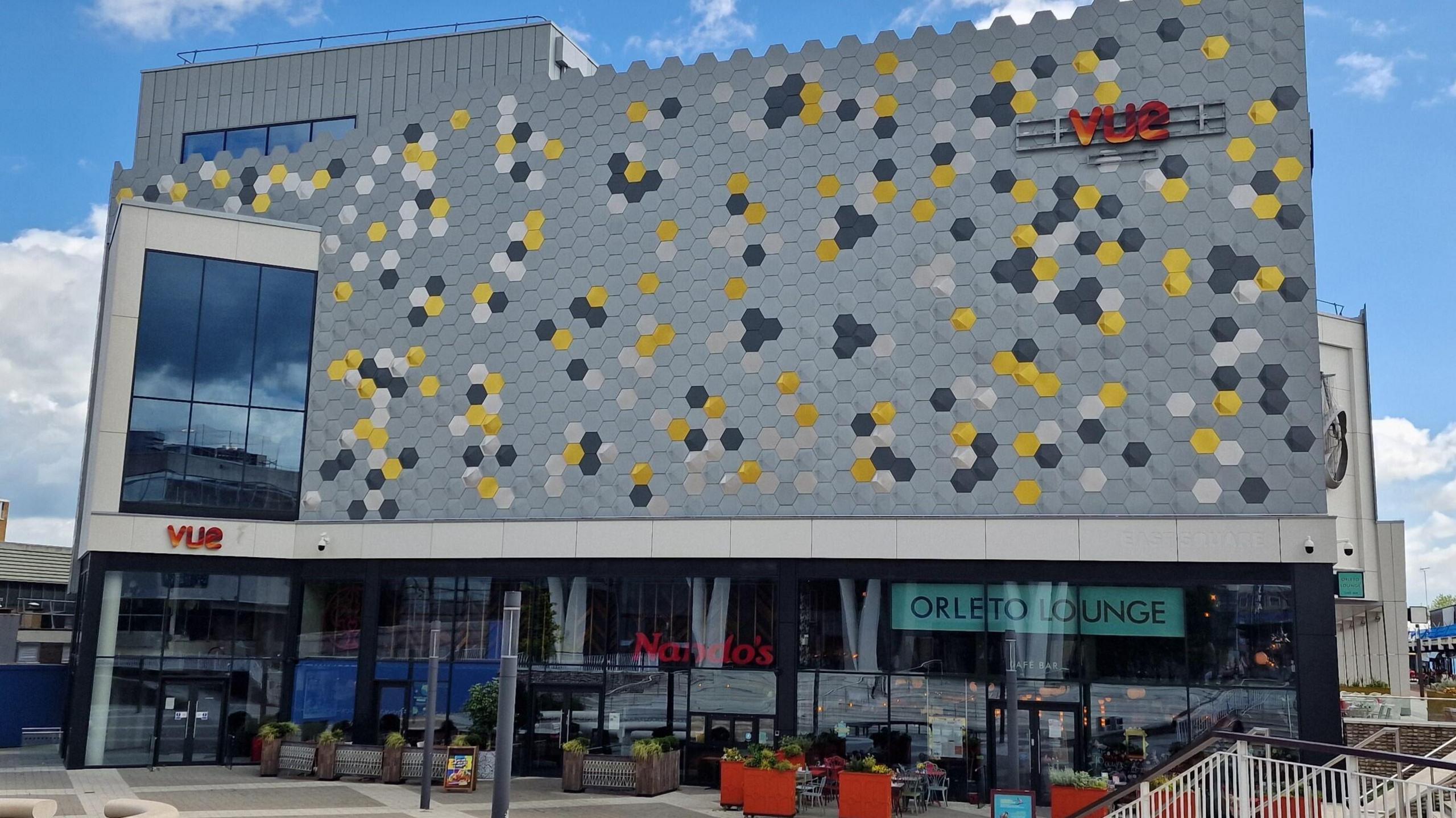 Image of the Vue cinema in Basildon, Essex. It has glass windows and a patio for outside seating