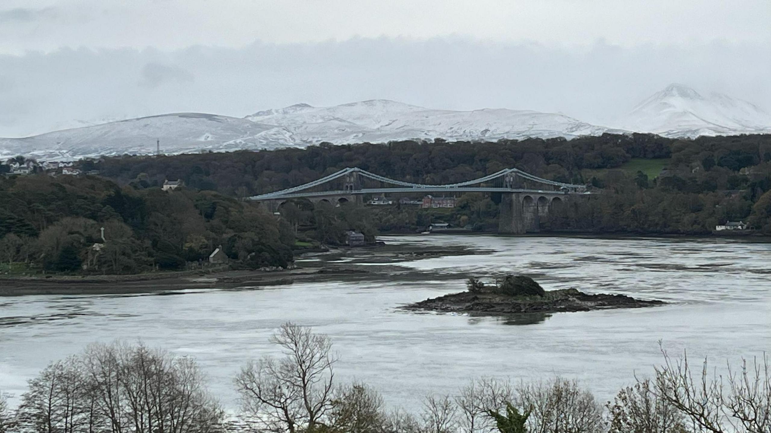 Golygfa o Ynys Môn o'r eira ar fynyddoedd Eryri