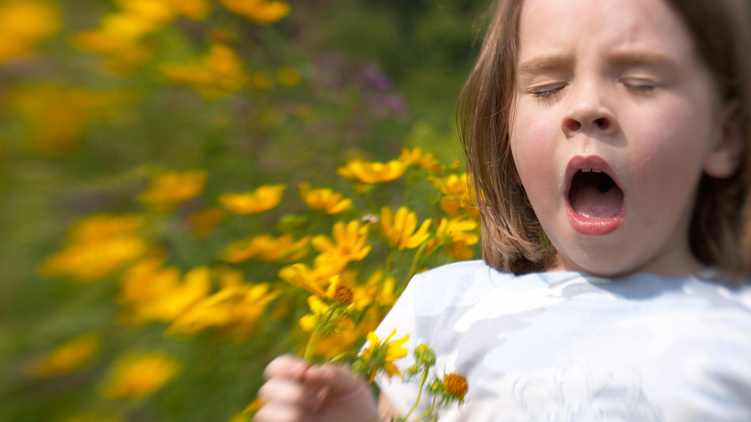 Girl in flowers sneezing