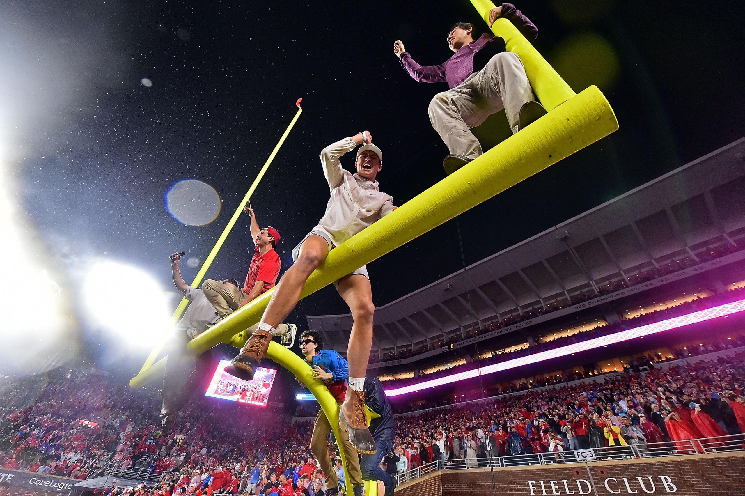 Fans sit atop the field goal after the game between the Mississippi Rebels and the Georgia Bulldogs at Vaught-Hemingway Stadium on 9 November 2024 in Oxford, Mississippi. 