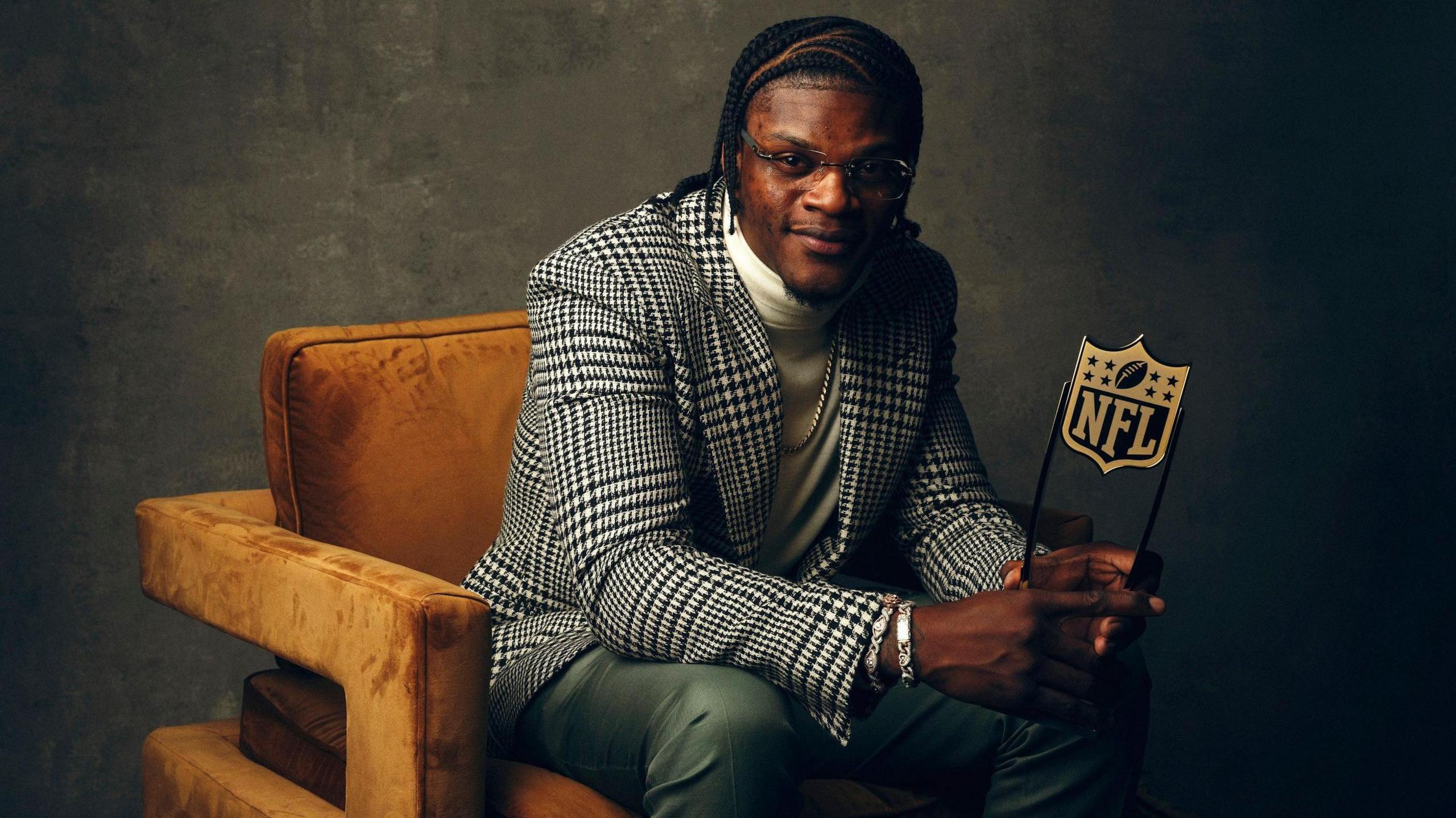 Baltimore Ravens quarterback Lamar Jackson poses with the 2023 NFL MVP trophy