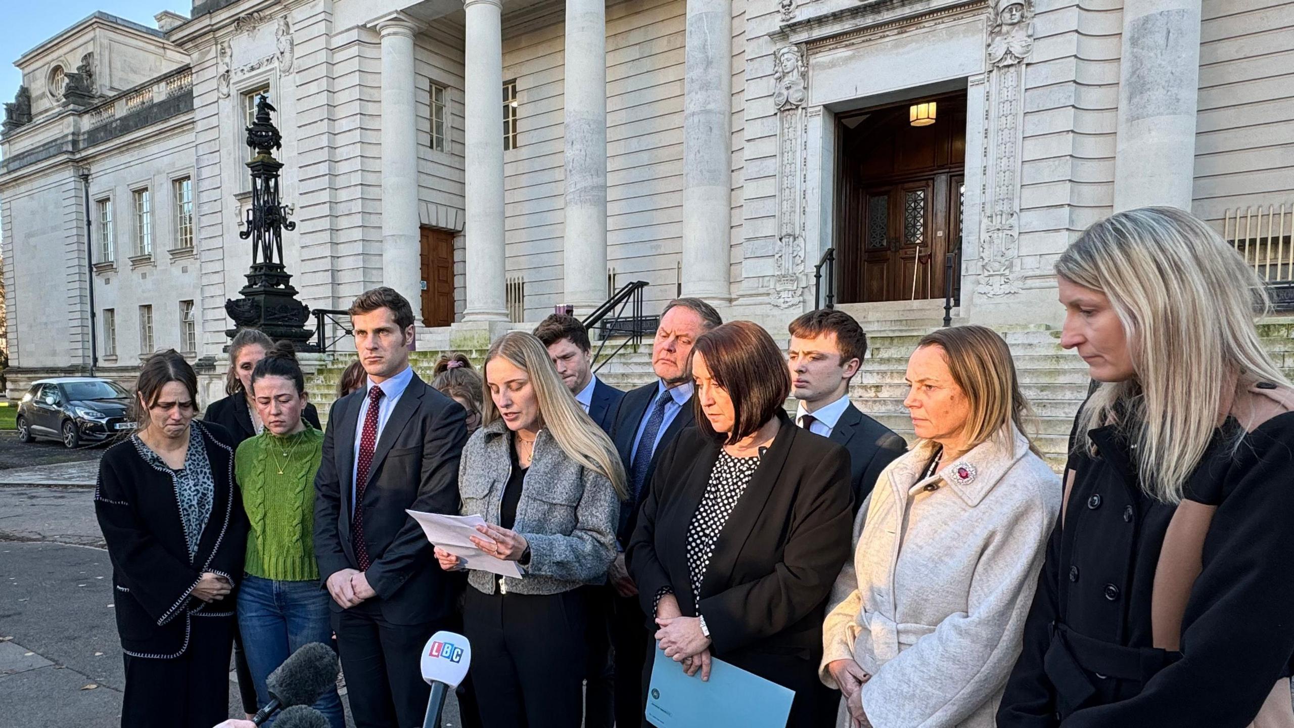 Members of William Bush's family, including his sister Catrin (centre) gathered outside Cardiff Crown Court to give a statement reacting to the verdict. Catrin Bush is reading from a sheet of paper into microphones