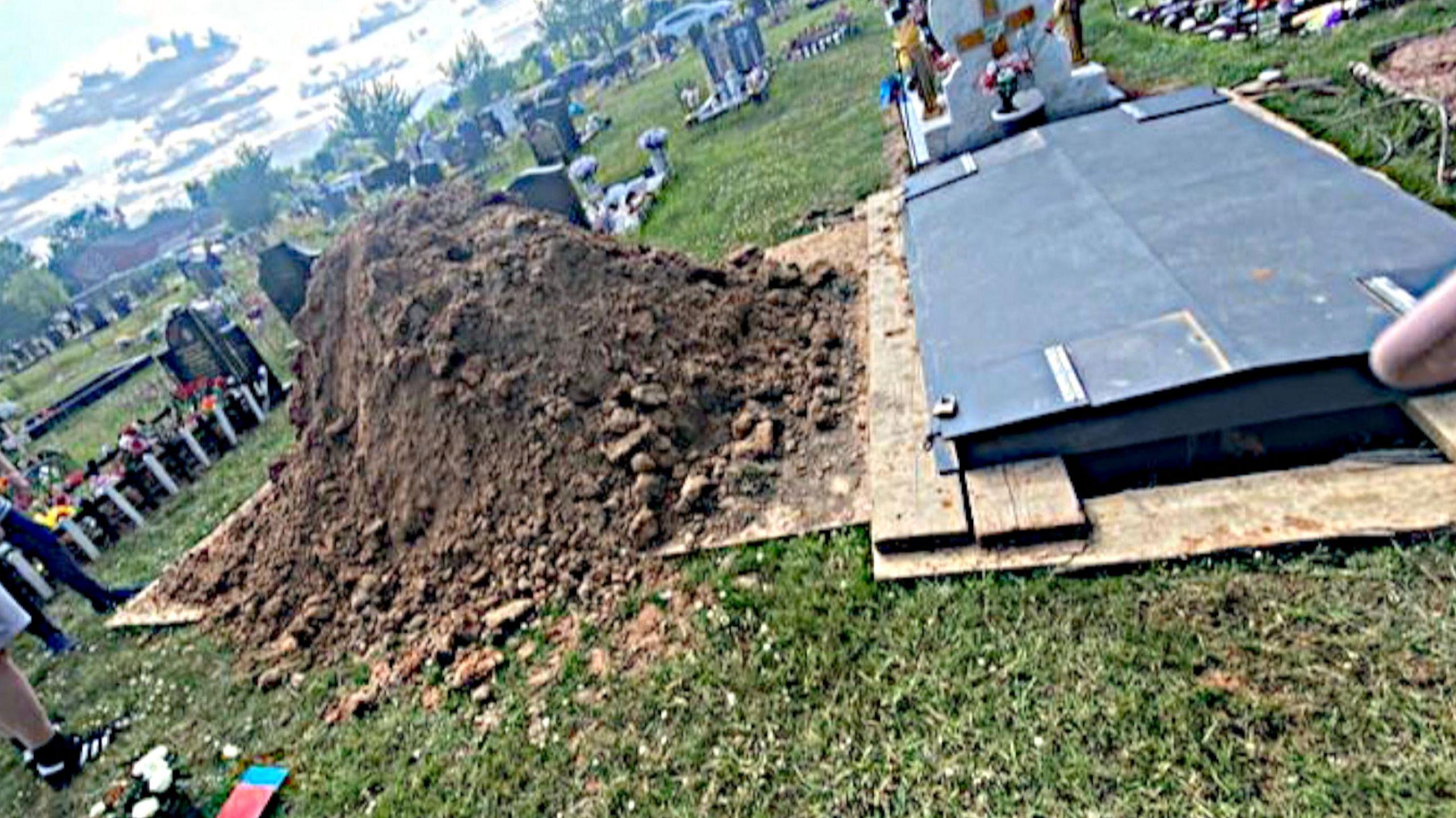 On the left is a pile of earth, covering the grave of Christopher Cooper. That earth has been dug to create a new grave on the right hand side of the picture.