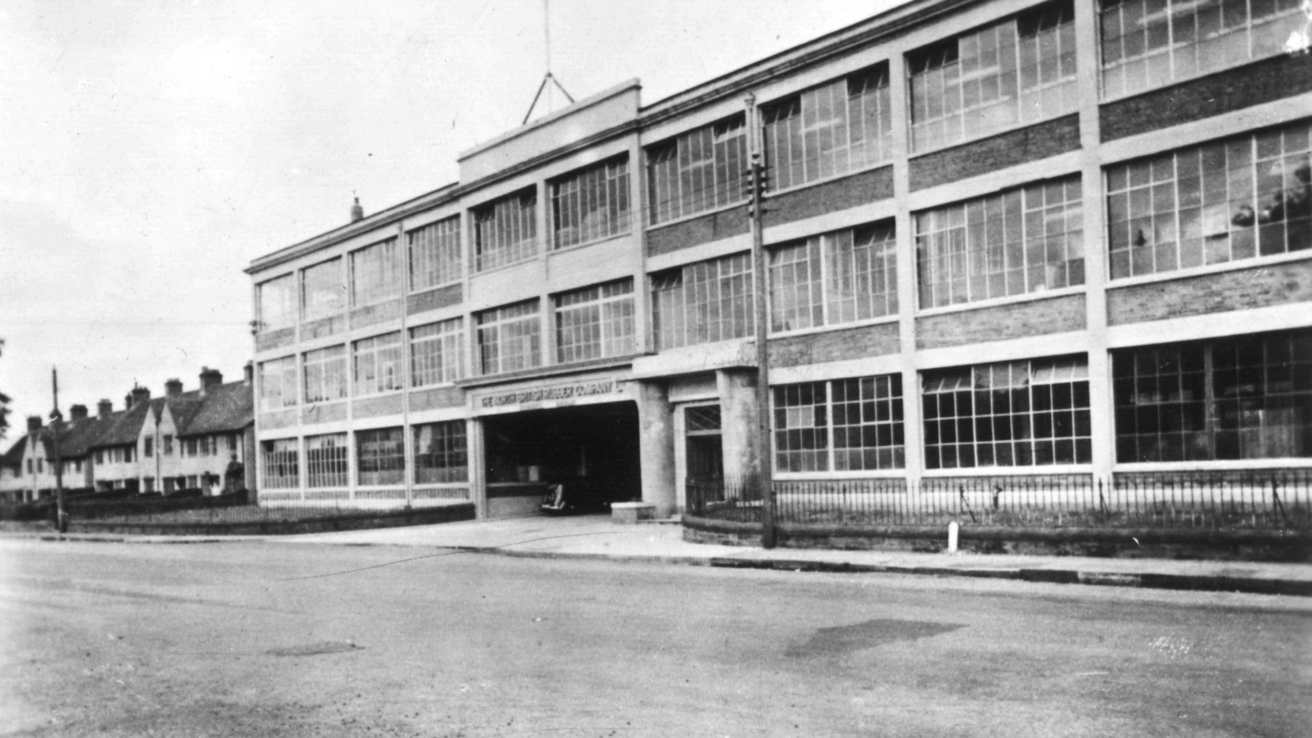 A black and white factory frontage with all its windows intact