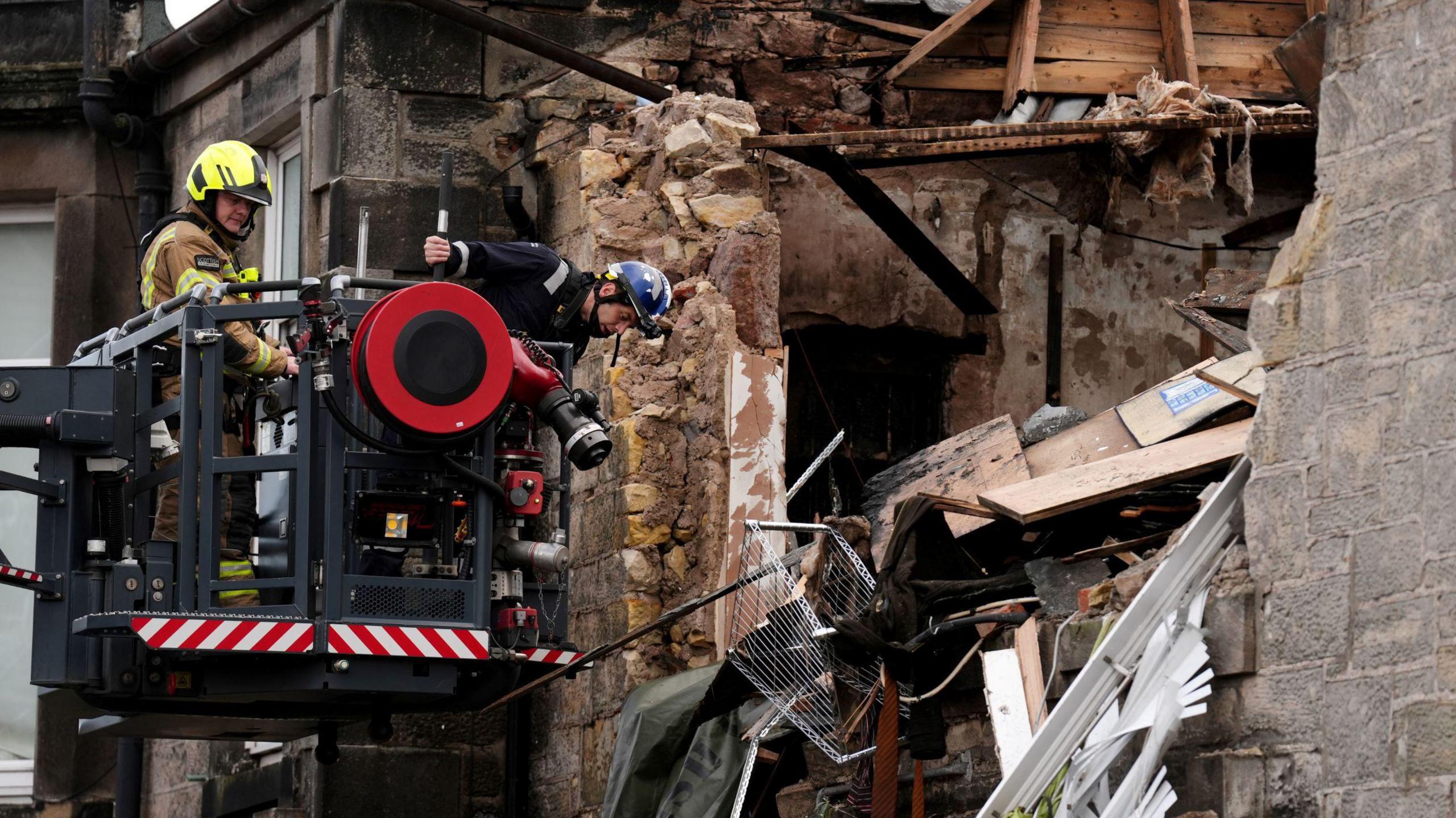 Emergency services use a raised platform to access the ruined flat that exploded in Alloa