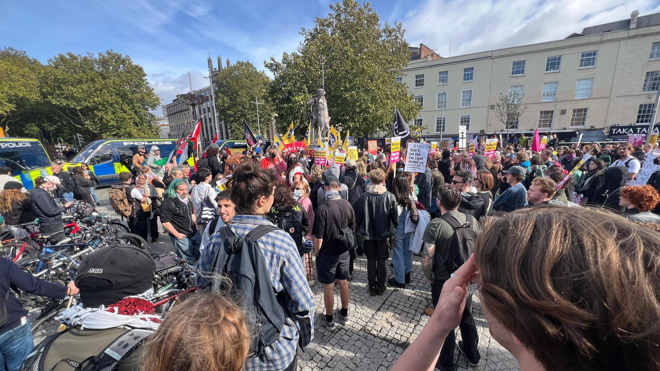 Counter protesters holding banners saying they oppose the far-right and welcome immigrants.