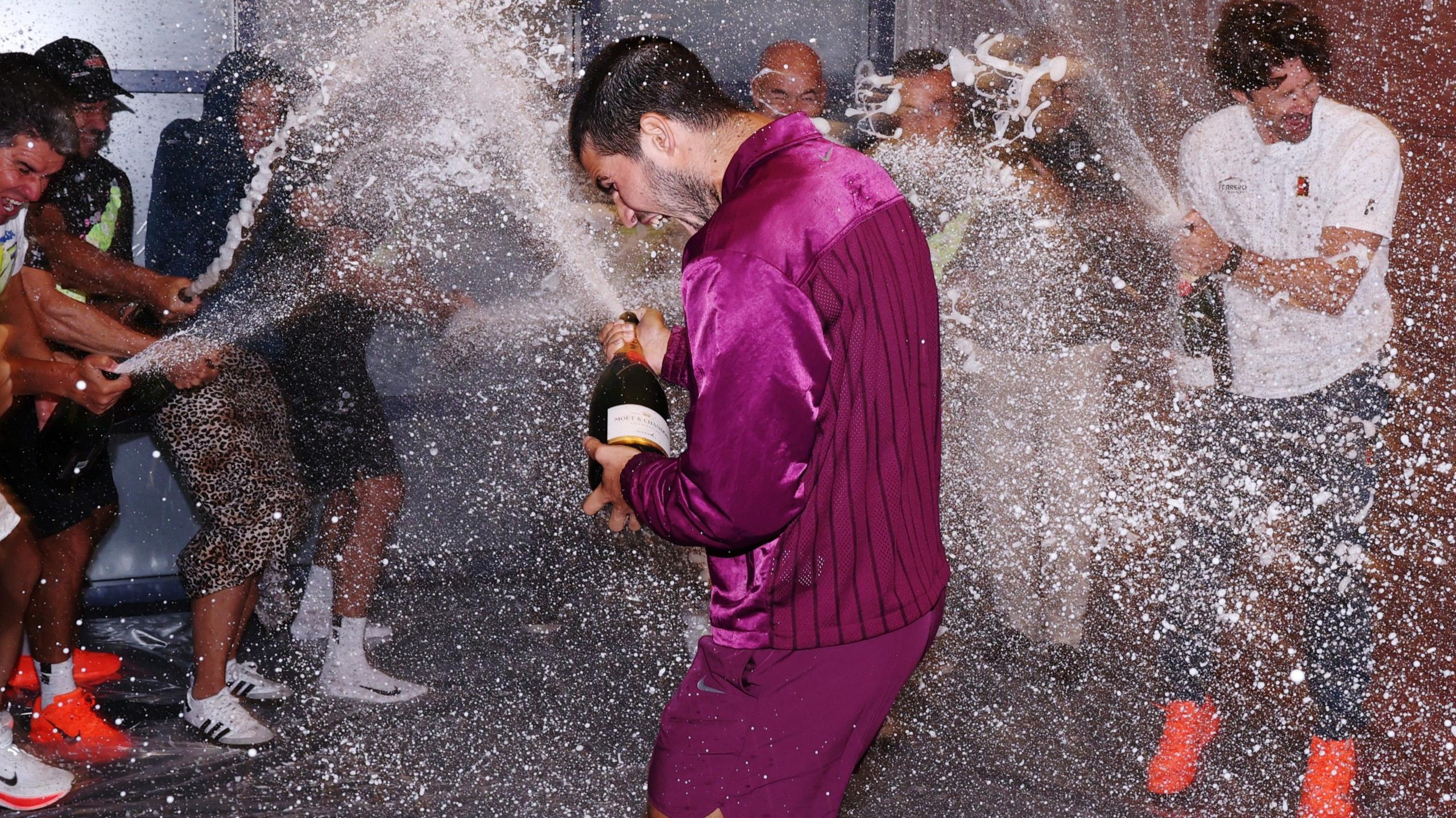 Carlos Alcaraz sprays his team with champagne after winning the US Open
