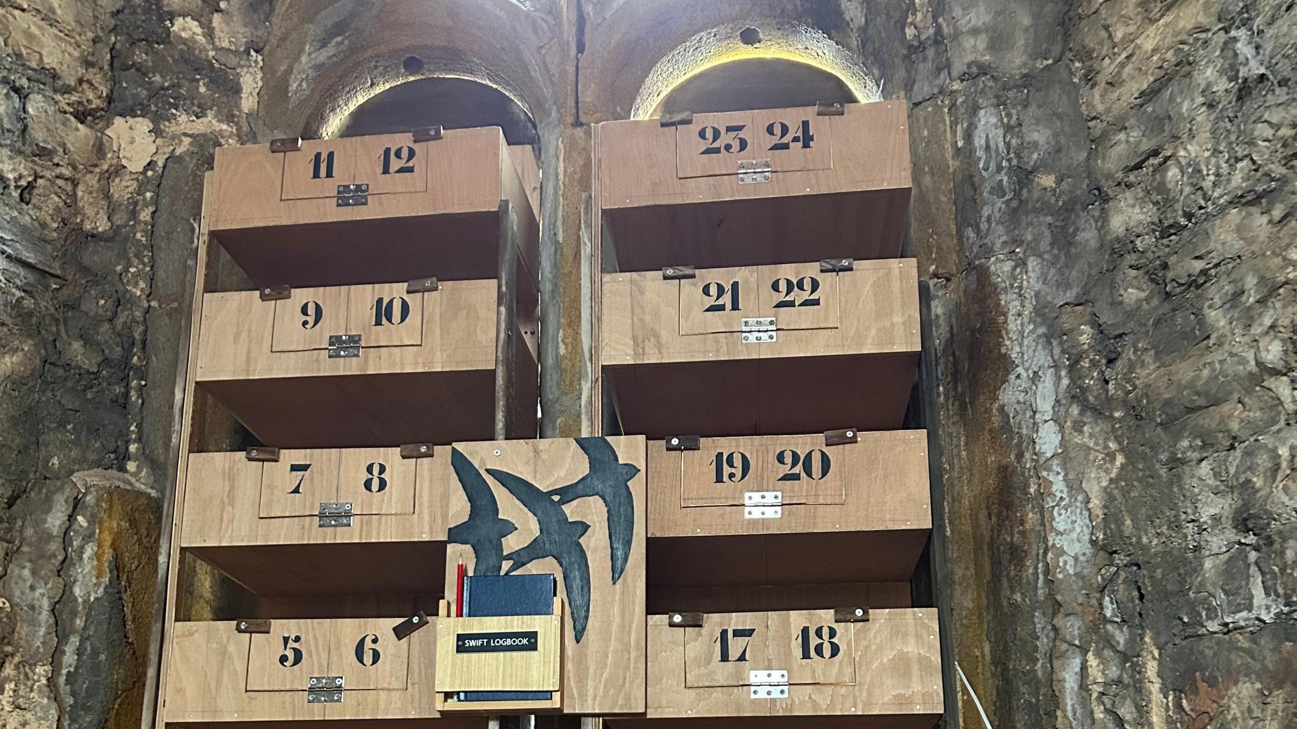 Swift boxes fitted into the window of a church bell tower.