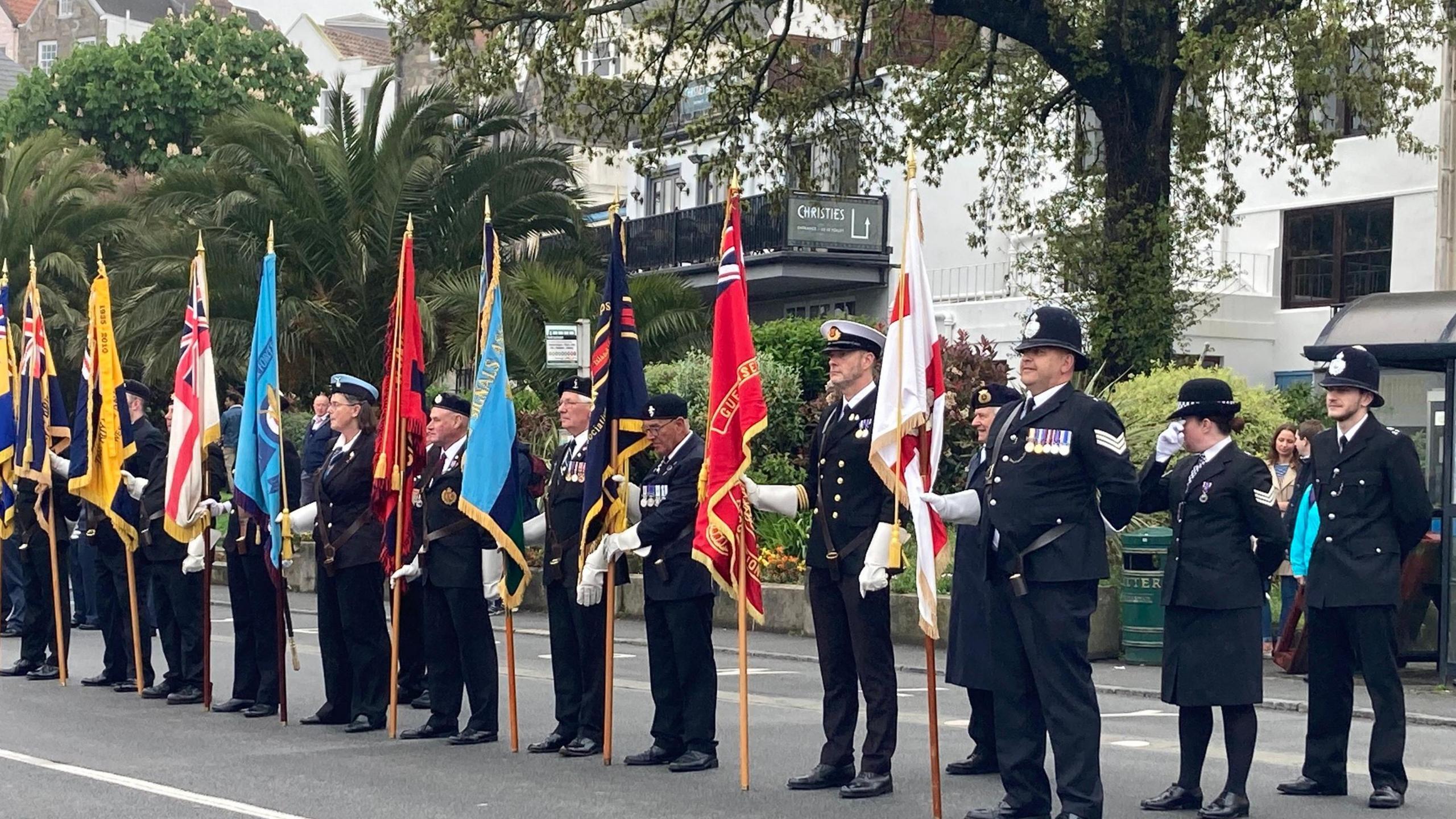 Line of ex-military personal with flags standing to attention