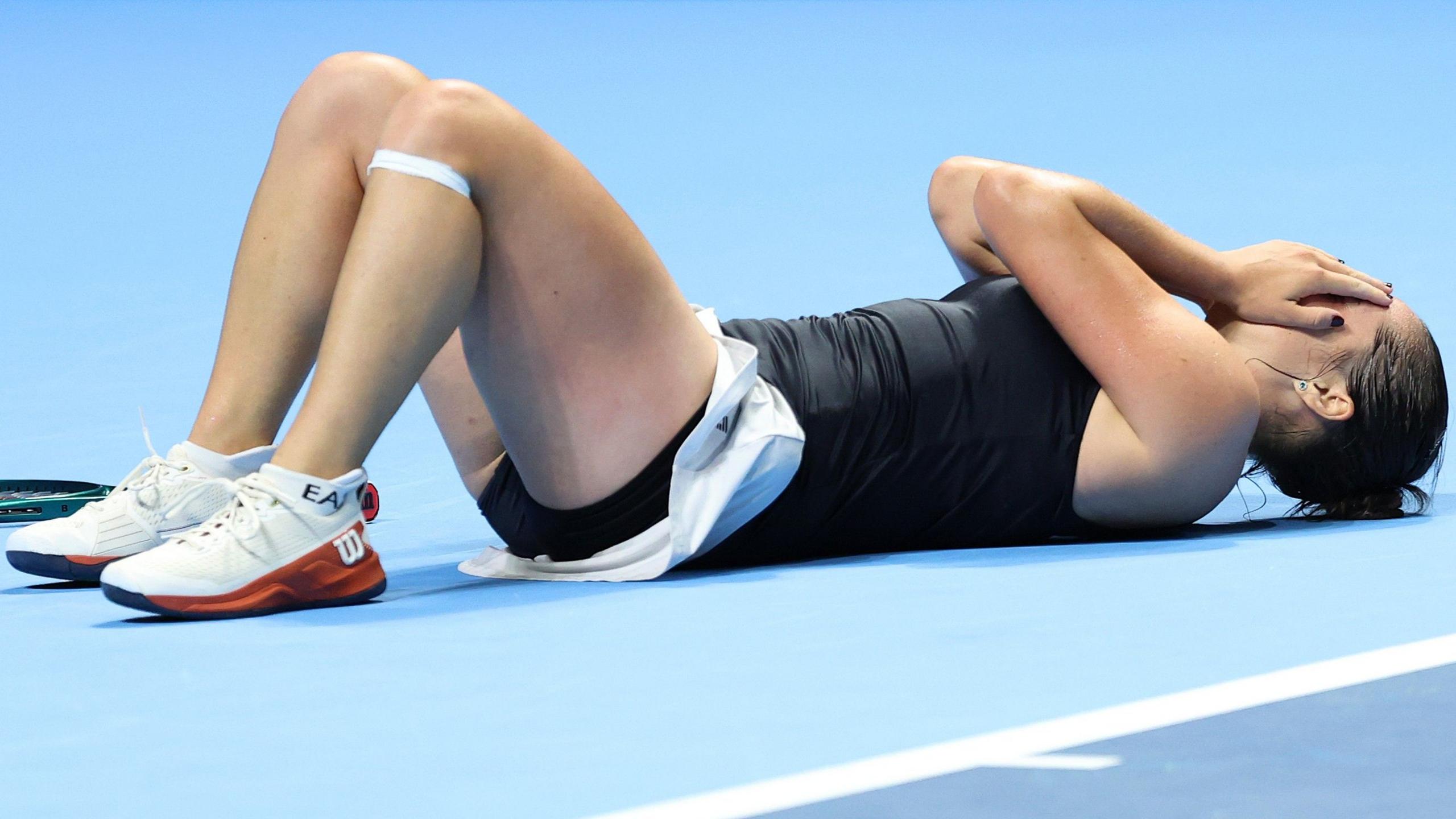 Italy's Elisabetta Cocciaretto throws herself to nan level aft triumph successful her Billie Jean King Cup quarter-final against China