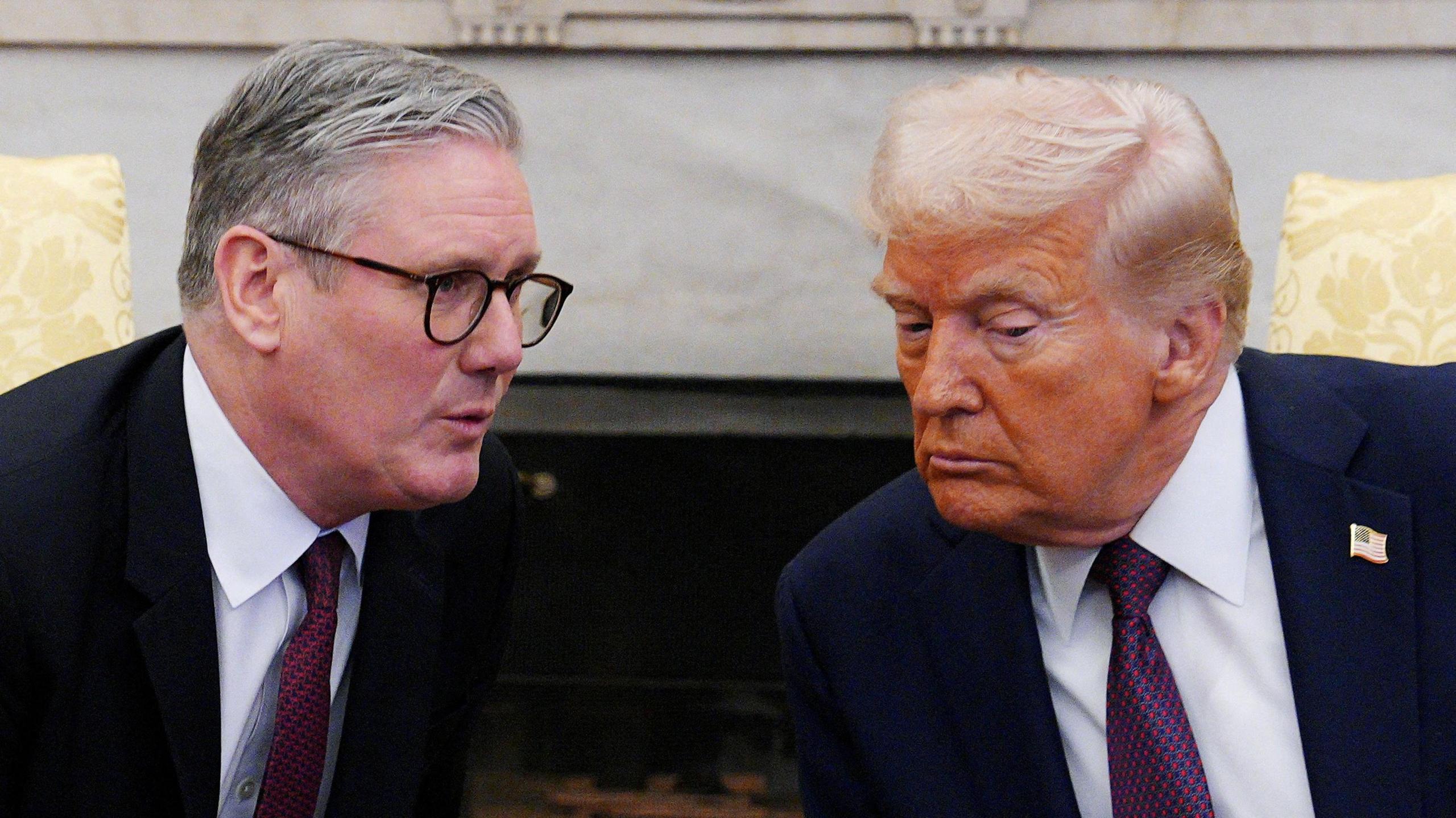 Sir Keir Starmer and US president Donald Trump lean into each other as they have a conversation. Both are wearing dark suits, white shirts and dark purple ties