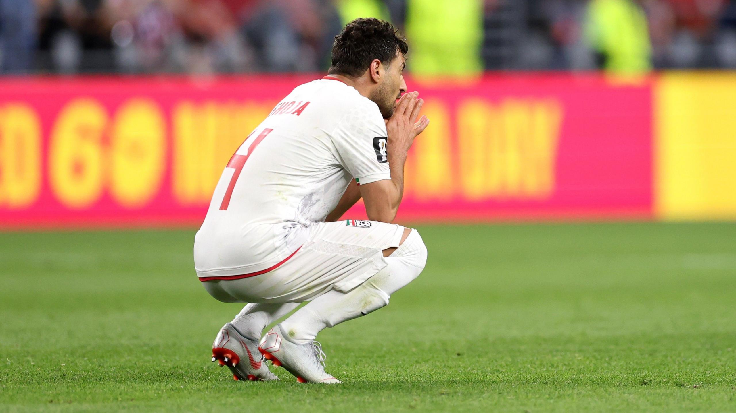 Shoja Khalilzadeh crouches down dejected