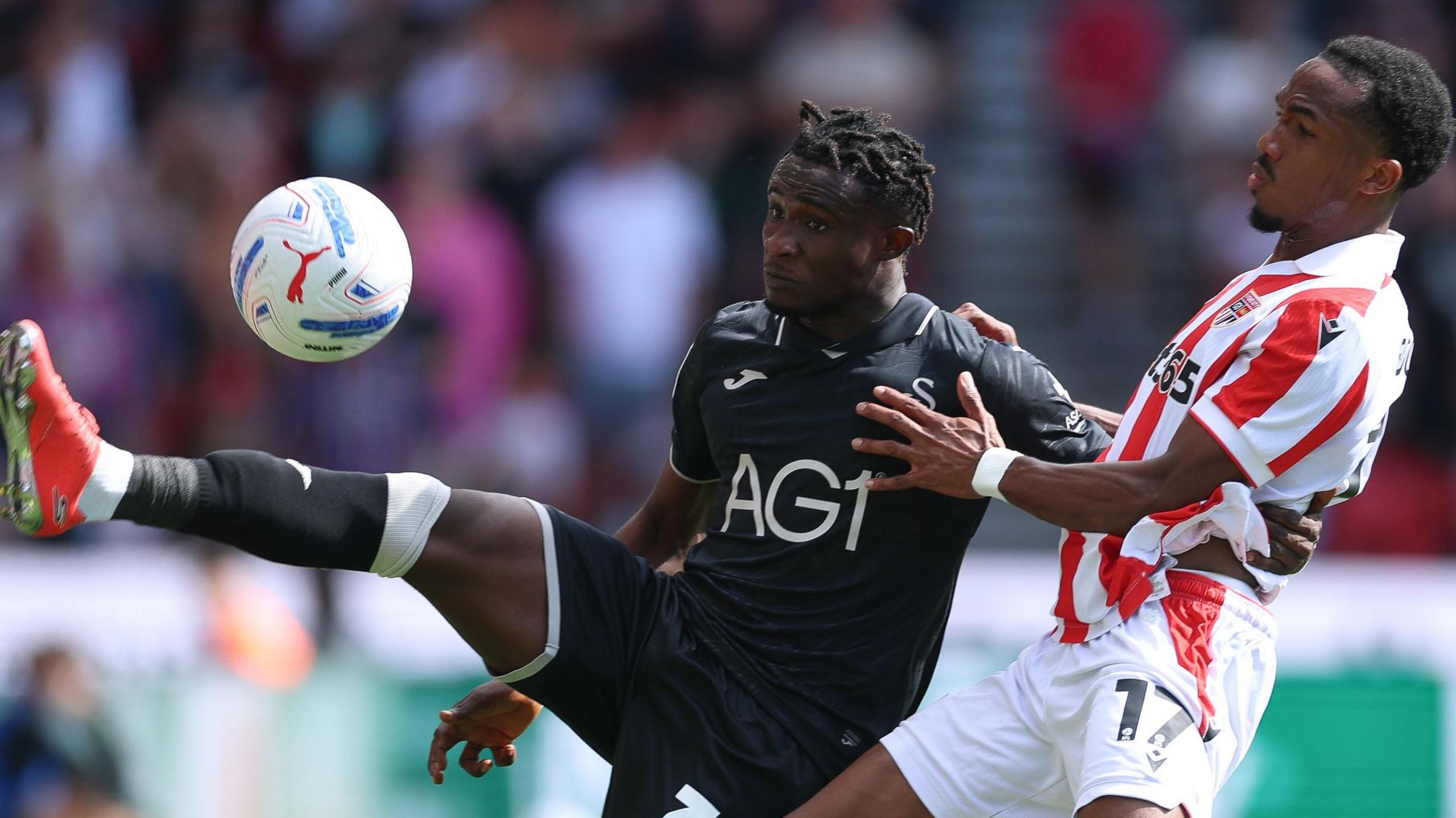 Joseph Opoku holds off Eric Bocat 