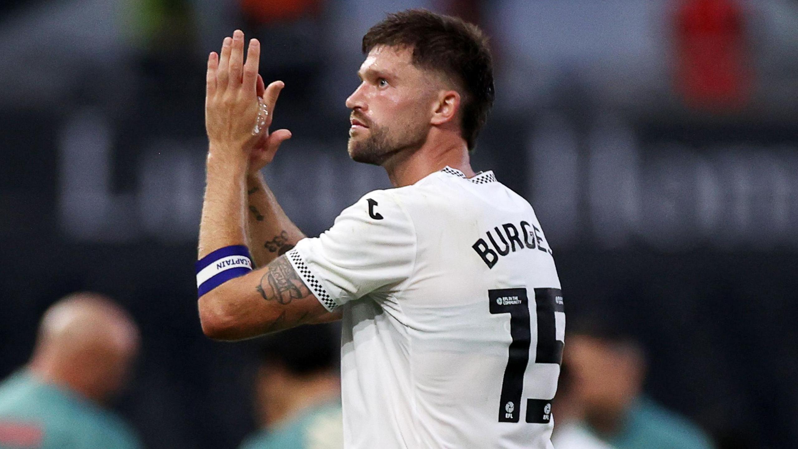 Swansea defender Cameron Burgess applauds crowd