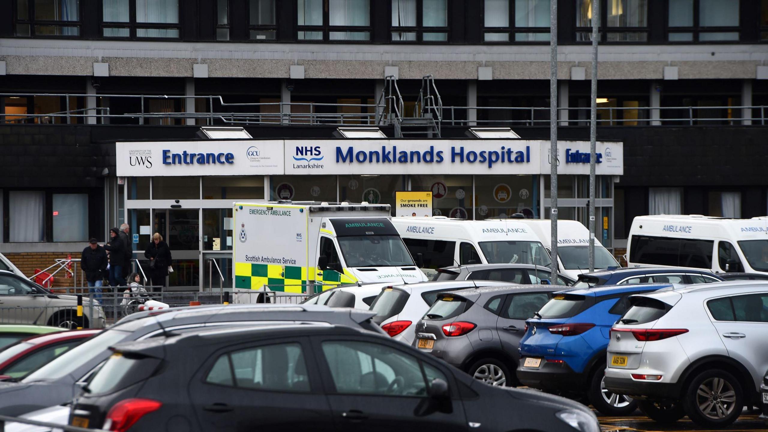 The entrance to University Hospital, Monklands, in North Lanarkshire - a number of cars and ambulances are parked in front of it.