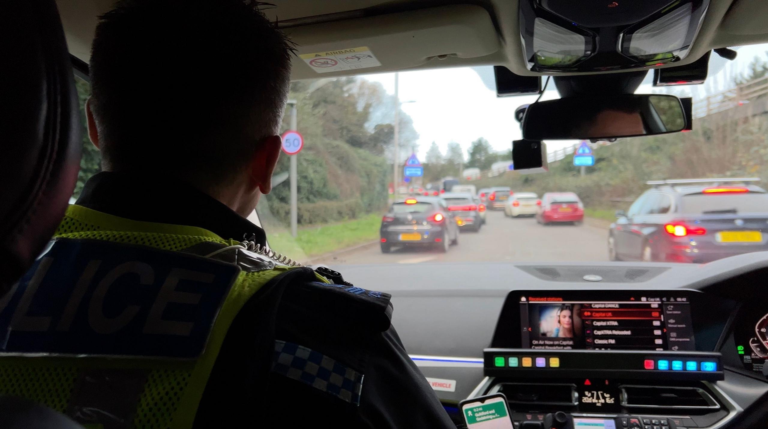 A police officer inside a police car.