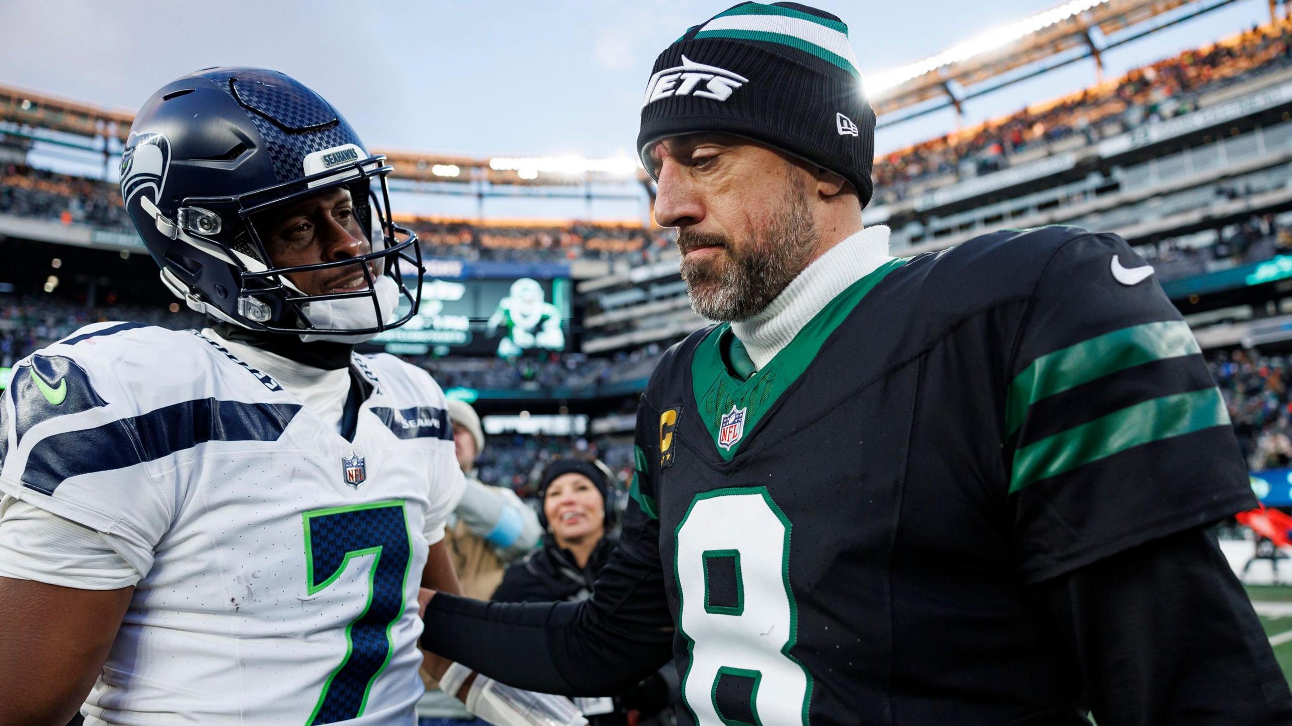 Seattle Seahawks quarterback Geno Smith talks to New York Jets quarterback Aaron Rodgers on the field at MetLife Stadium after their NFL game