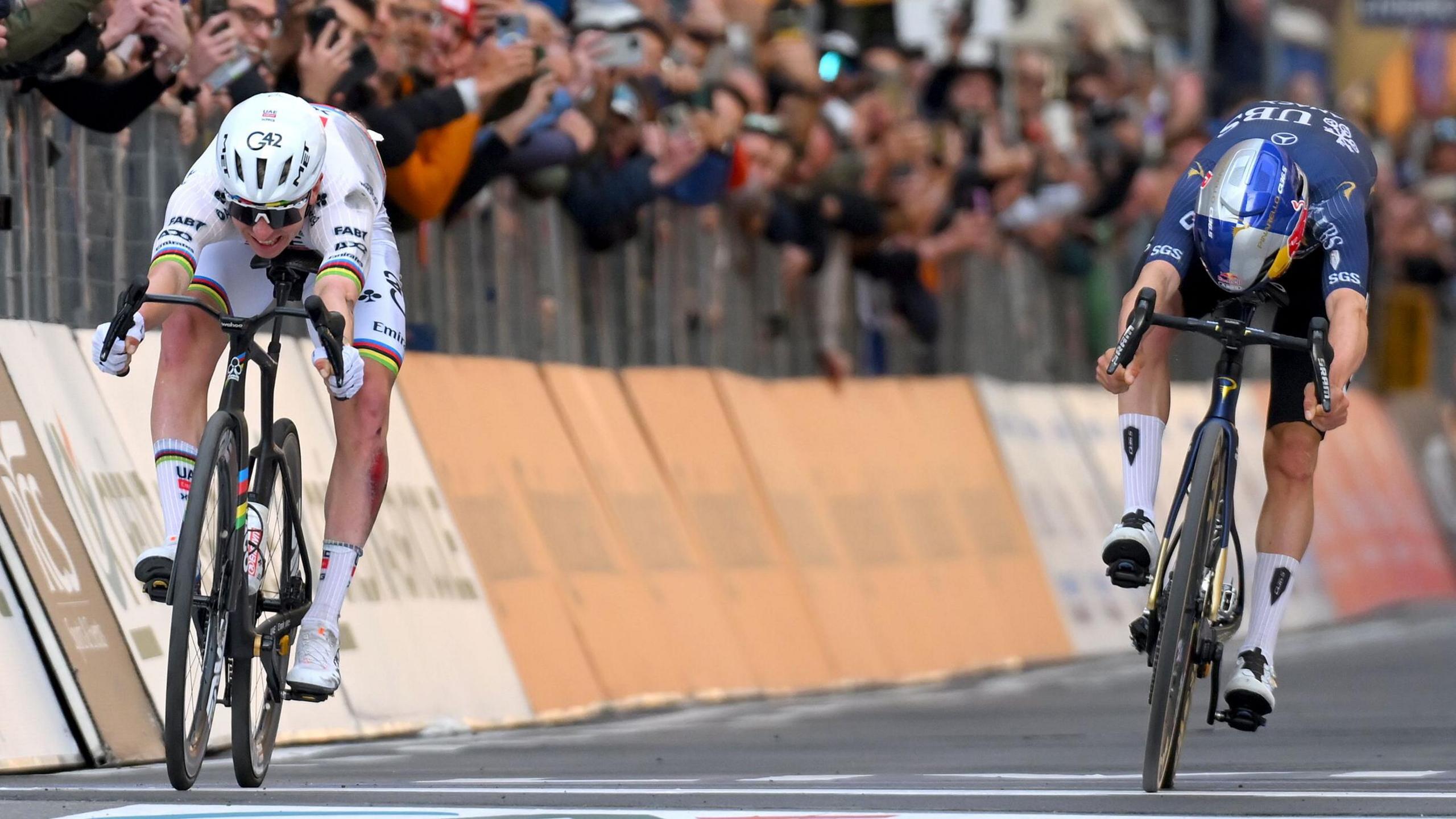 Tadej Pogacar (left) and Tom Pidcock (right) throw their bikes towards the finish line at Milan-San Remo