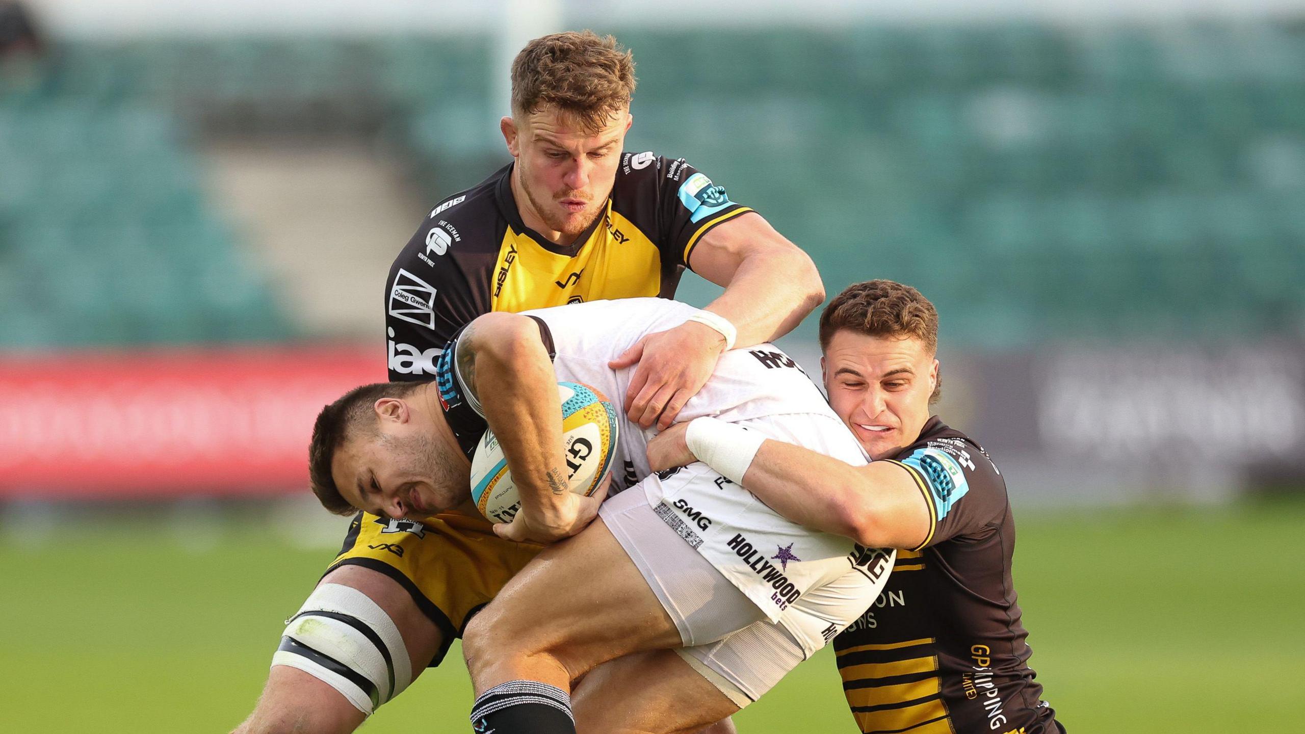 Andre Esterhuizen of Hollywoodbets Sharks is tackled by Harry Wilson of Dragons and Shane Lewis-Hughes of Dragons 